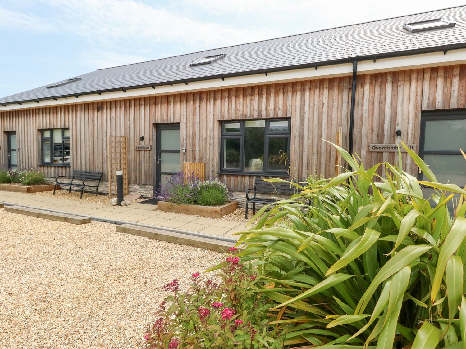 A building exterior with benches and gardens at Corvesgate Nottington near Weymouth