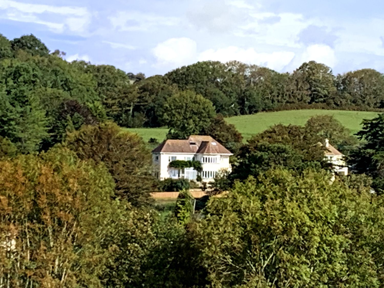 A house surrounded by trees and fields at Westdale Edge in Seaton Devon