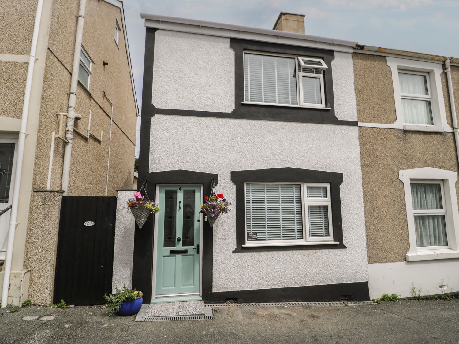 A house with a front door and flower pots at 4 Haven Villas in Conwy