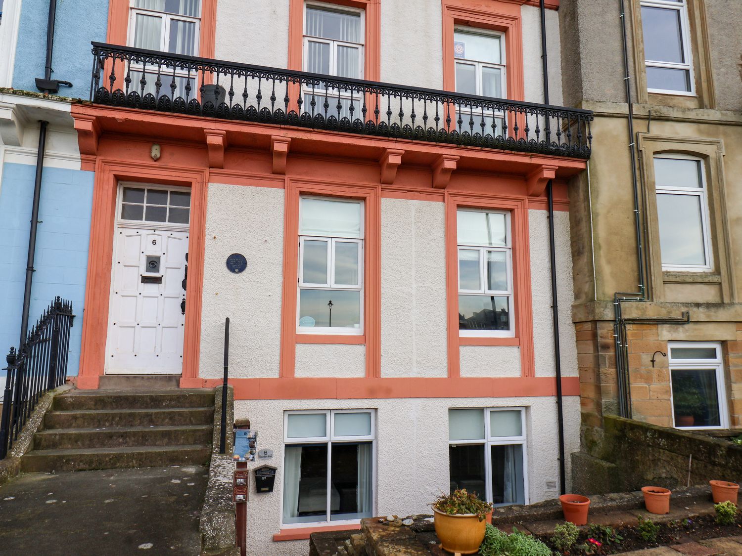 A multi-story residential building with white walls and orange trim at Brams Lair in Whitby