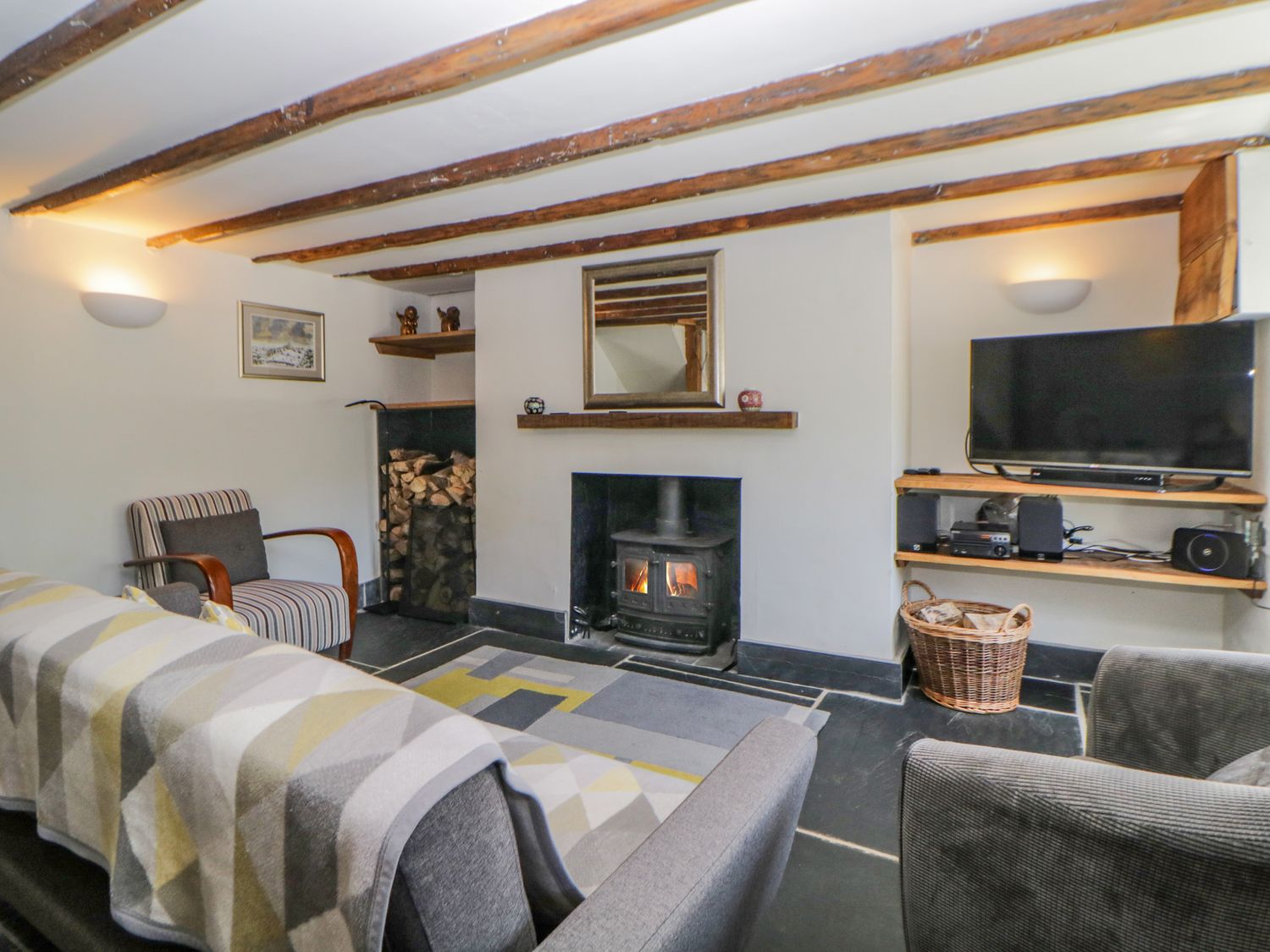 A living room with a wood stove fireplace tv and seating at Burham Cottage Walkhampton near Yelverton