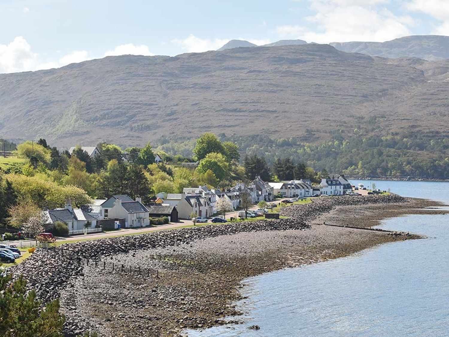 A coastal village with houses along the shore and mountains in the background at Tigh en Leigh in Shieldaig