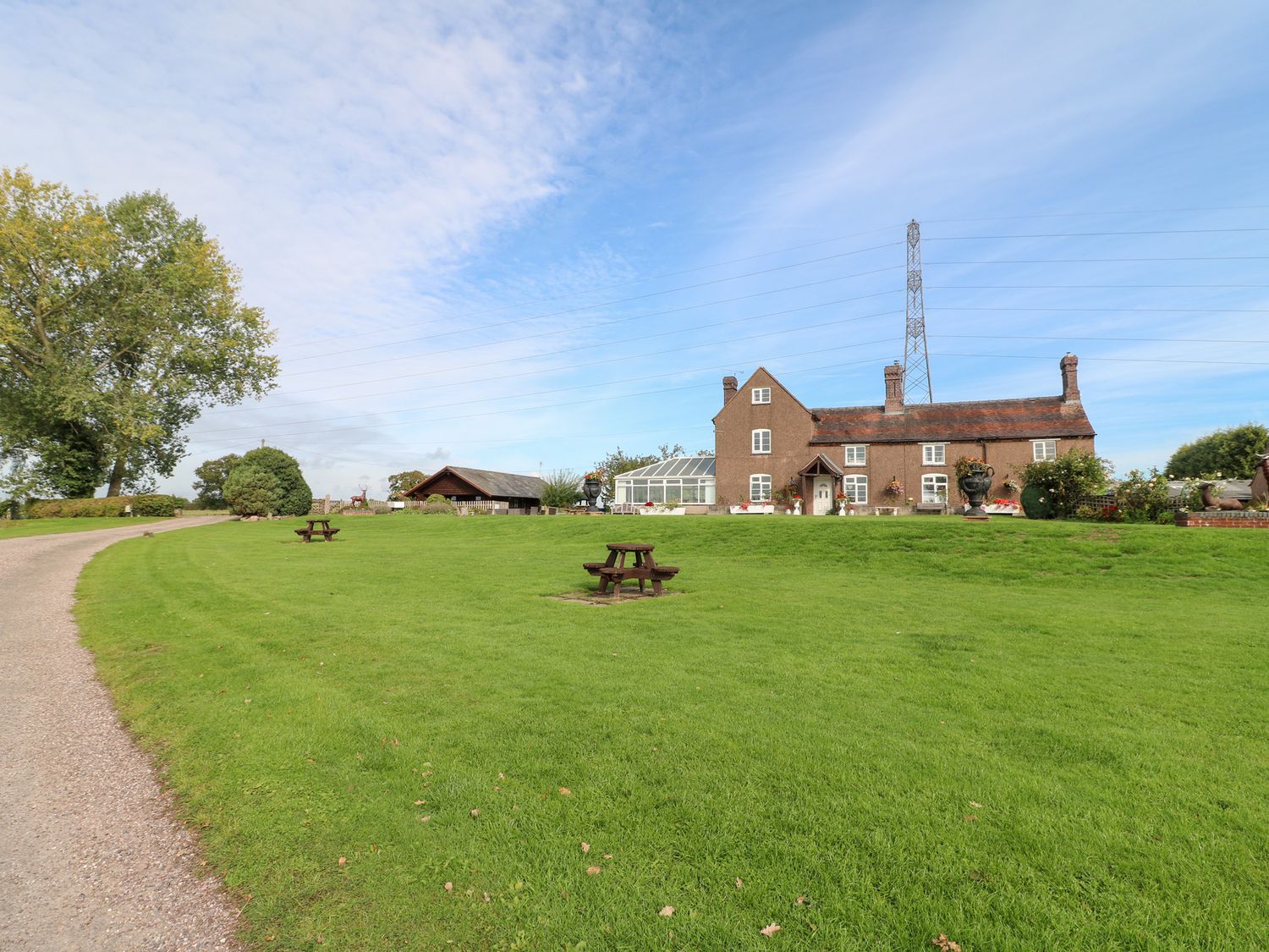 An outdoor area with a house and greenhouse at Far Coley Farm and Kilnhurst Log Cabin Great Haywood