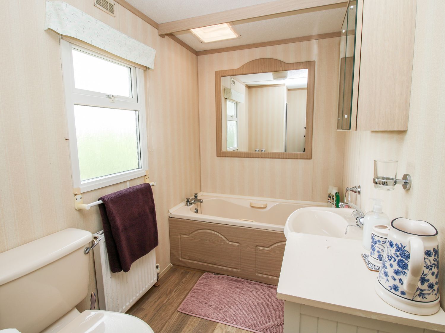 A bathroom with a bathtub toilet sink and a towel hanging on a radiator at 7 Old Orchard Brockton near Much Wenlock