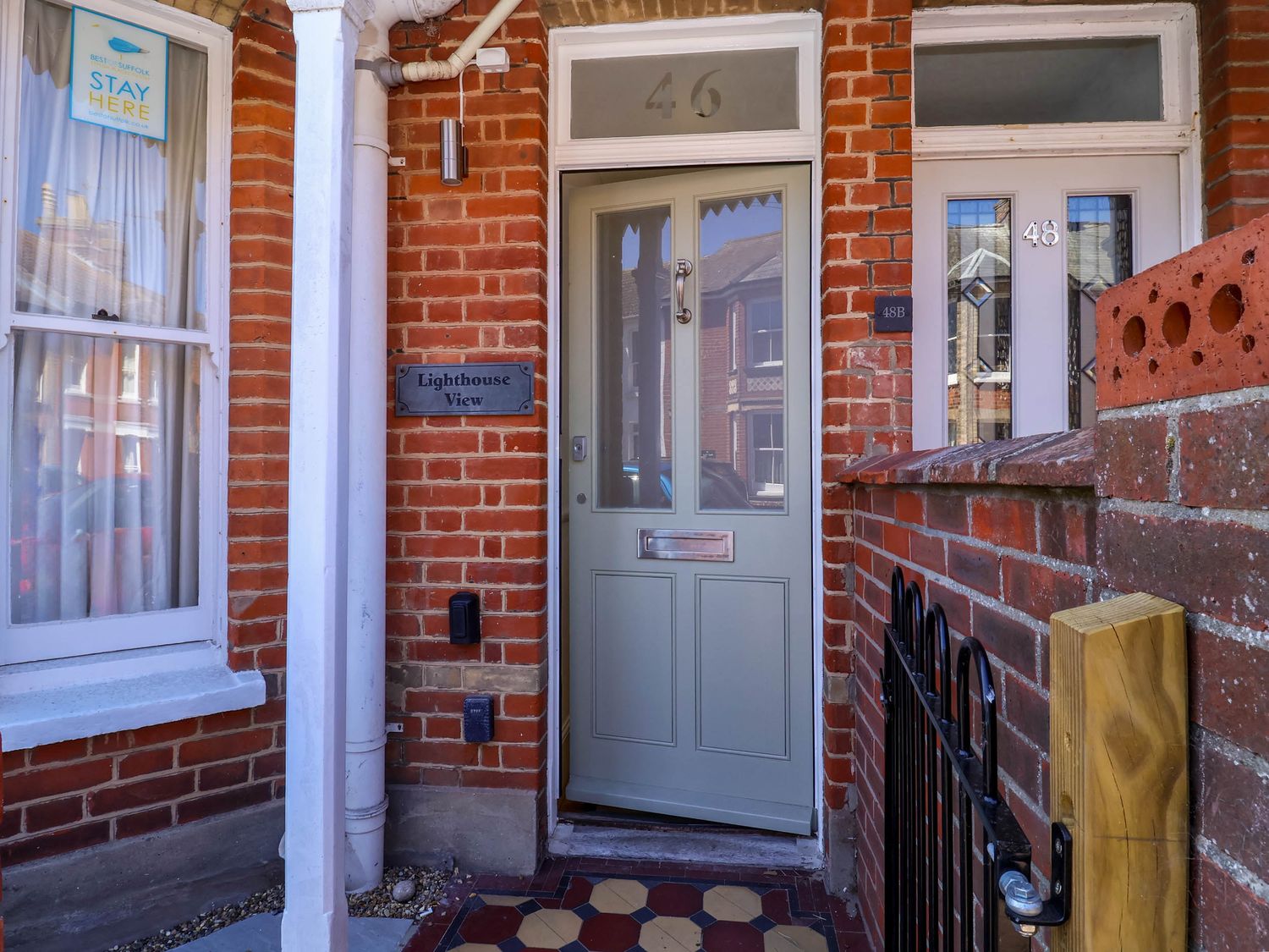 Entrance door numbered 46 with a Lighthouse View sign on a red brick house in Southwold