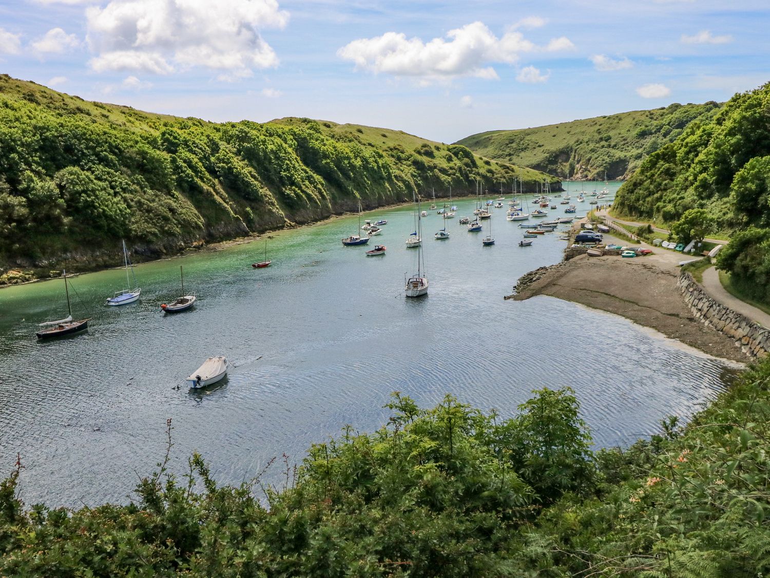 A river with sailboats and green hills on both sides at Bay View Farmhouse in Penycwm near Solva