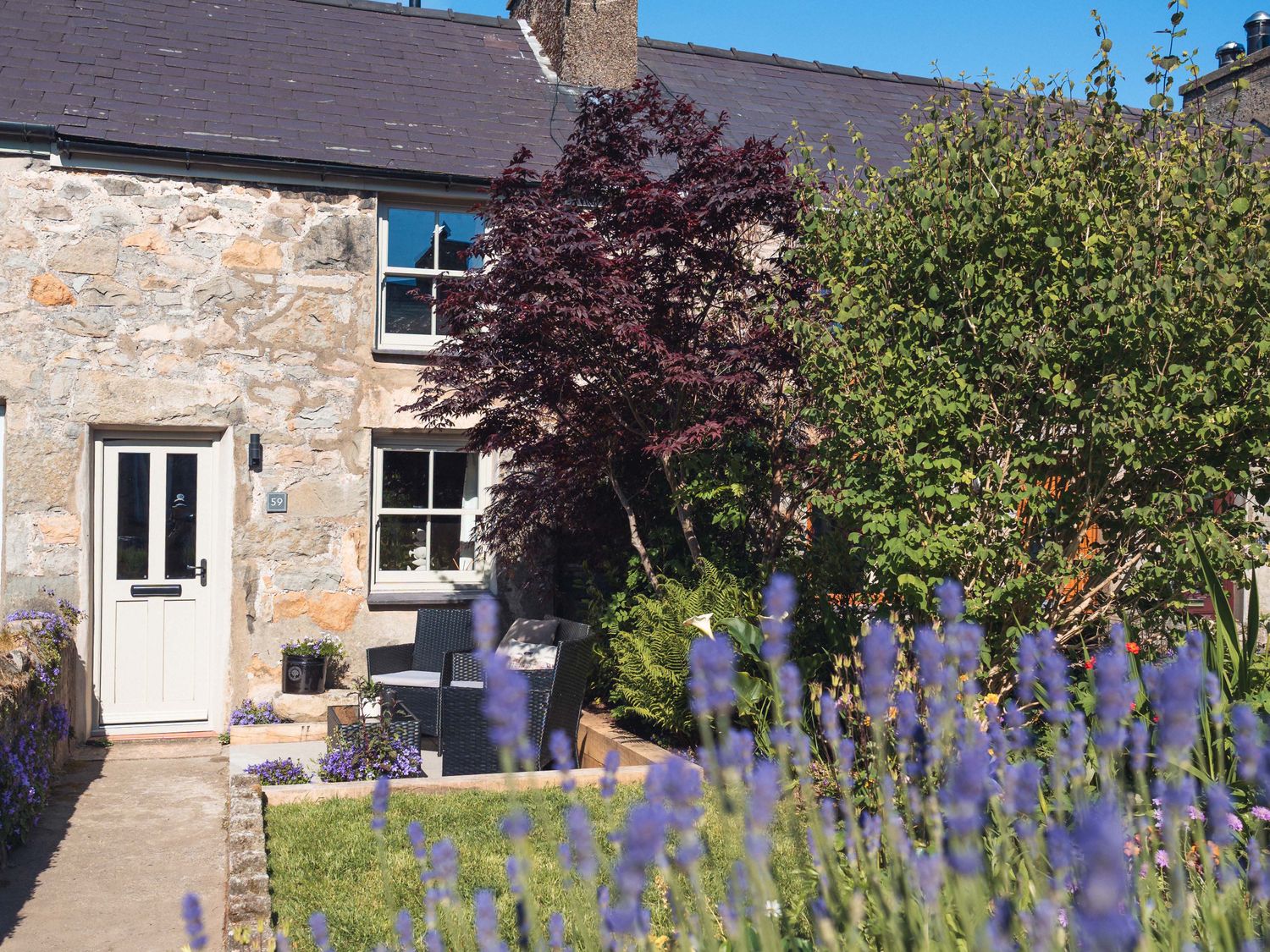 A stone house with a front door and outdoor seating at Ynata Trefor