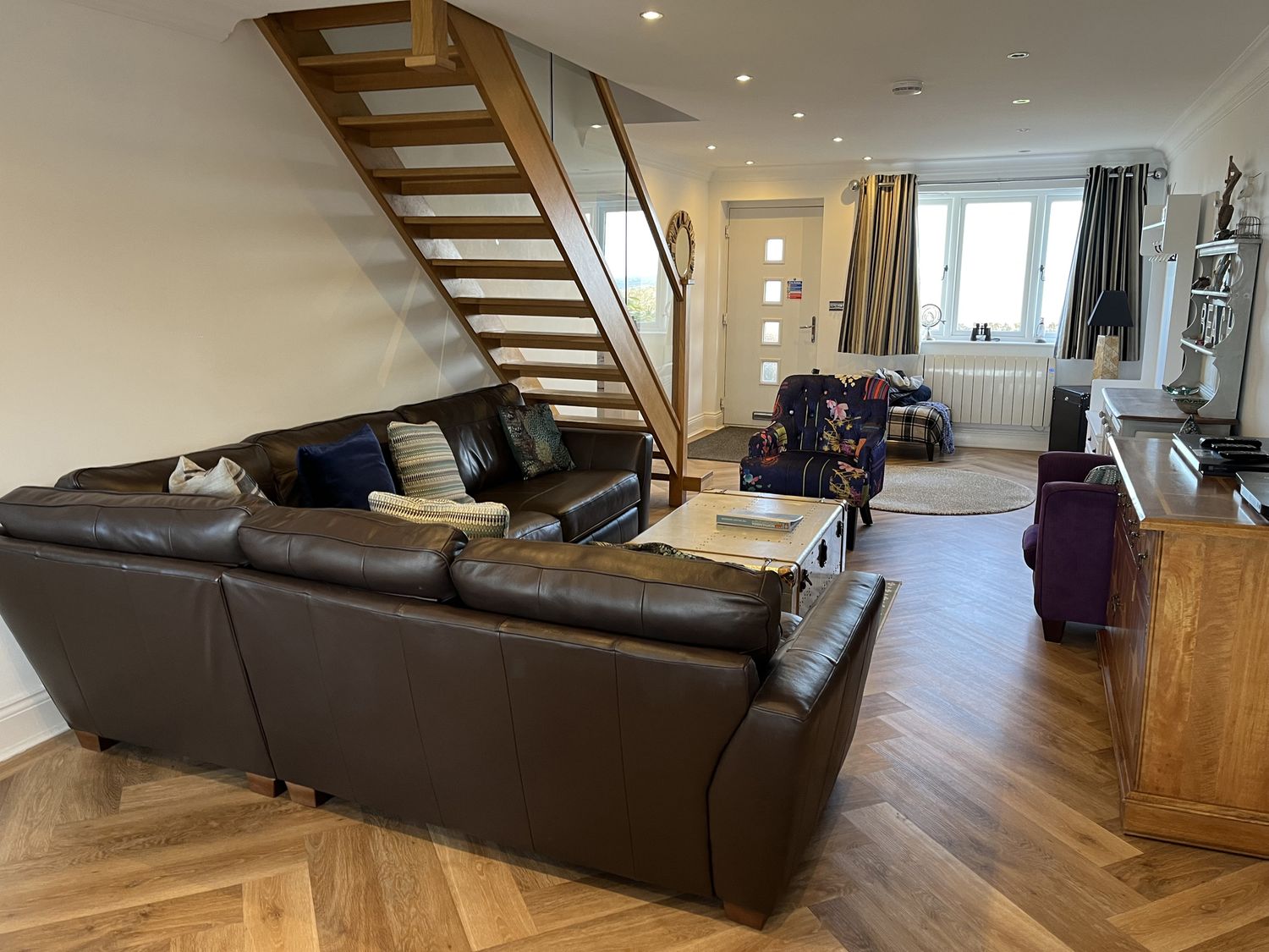 A living room with a sofa and staircases at Farne Cottage in Beadnell