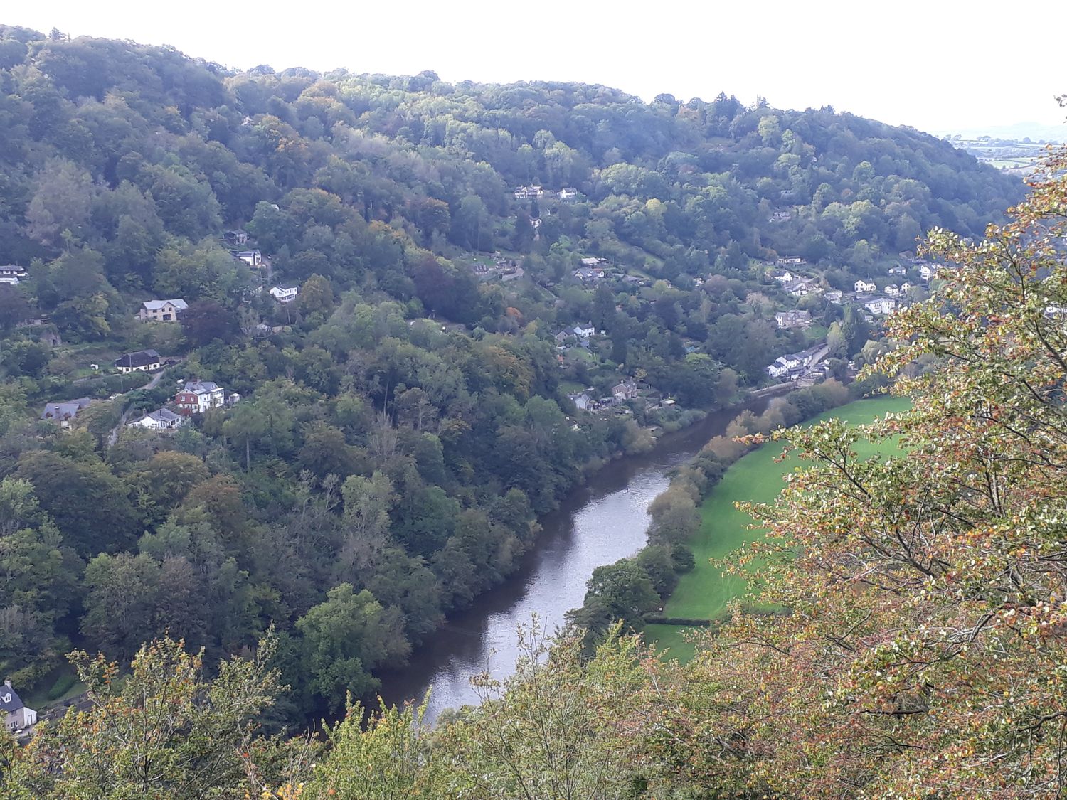 A river flowing through a valley with houses on the hills and green fields at 2 The Old School in Ruspidge