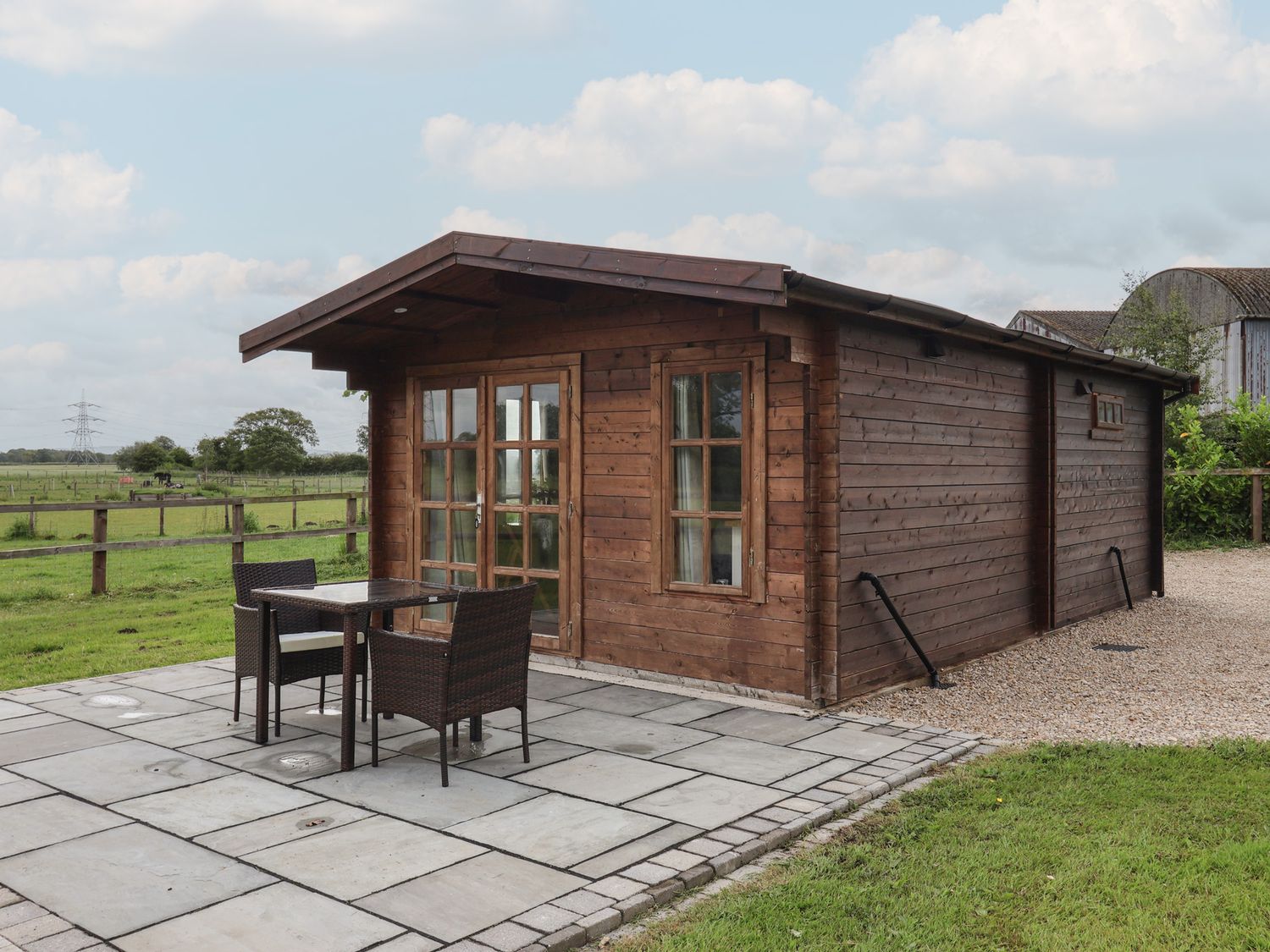 A wooden cabin with outdoor seating and patio at Lodge 1 in Strensall