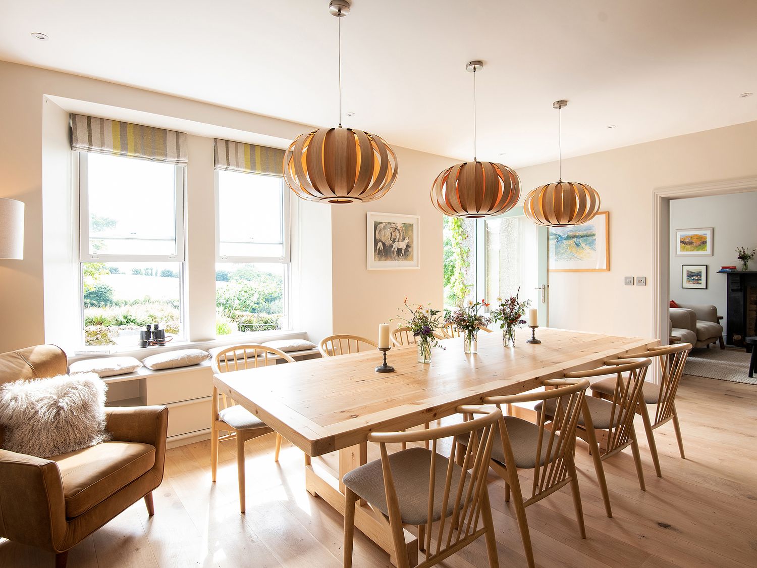 A dining room with a large table and pendant lights at Treveddoe Farmhouse in Bodmin Moor