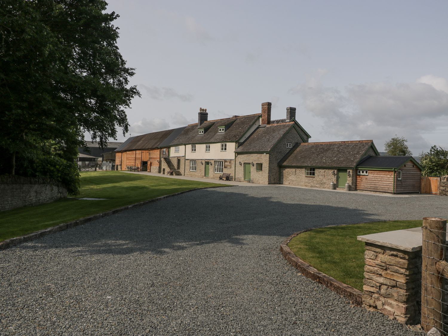 An outdoor view of a house with a gravel driveway at Evenjobb Court Farmhouse Evenjobb near Presteigne