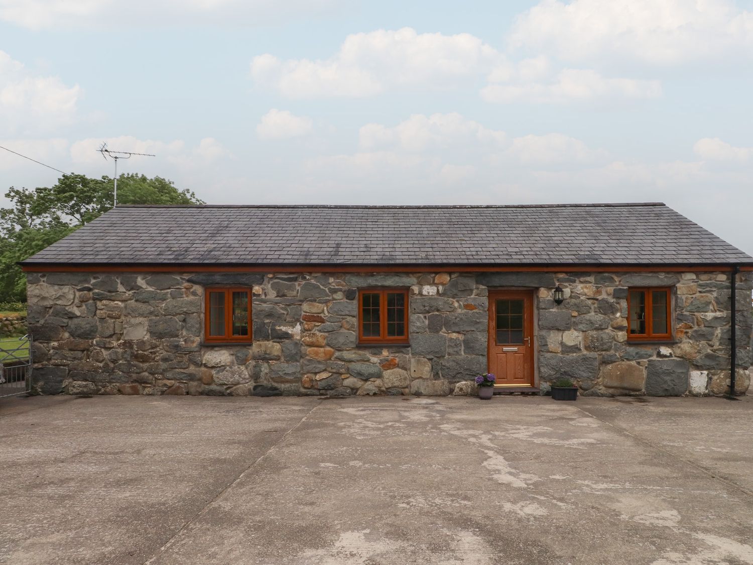 A stone cottage with windows and a door at Bryn Caled in Llanarmon near Y Ffor