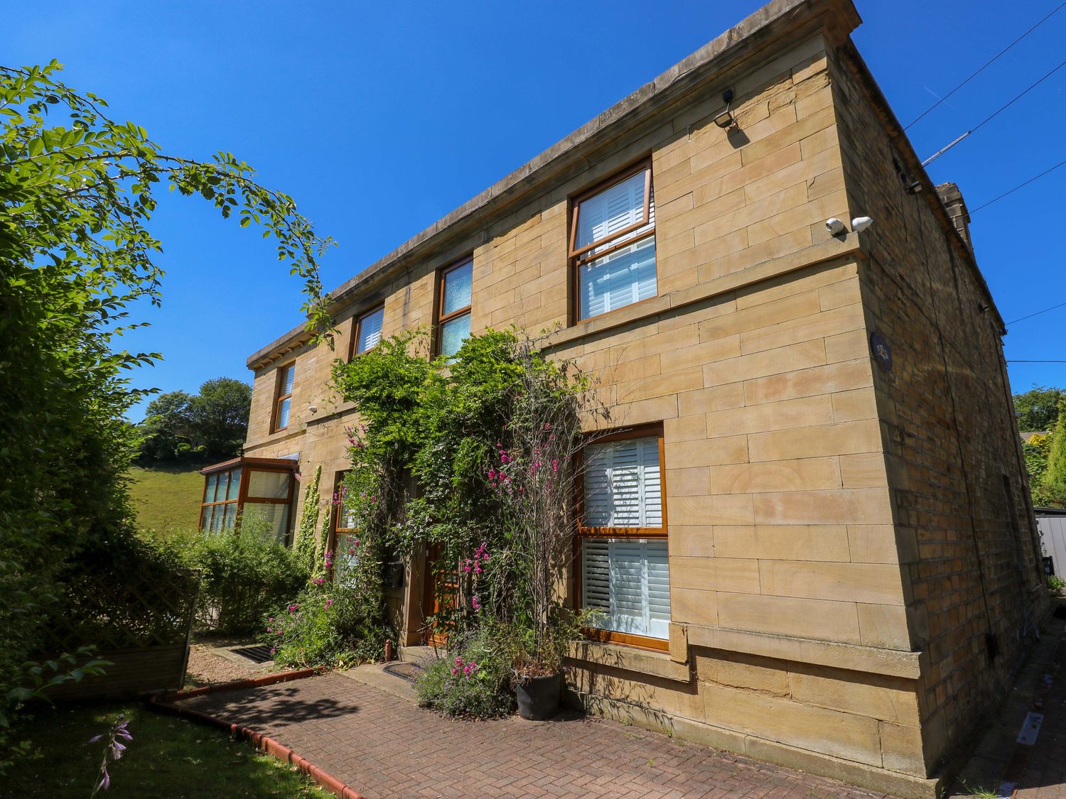 A house with windows and a pathway at The Old Post Office - Pet Friendly Group Stays in Holmfirth