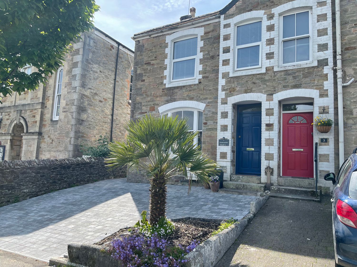 A house with two doors and a palm tree at The Oystercatcher in Falmouth