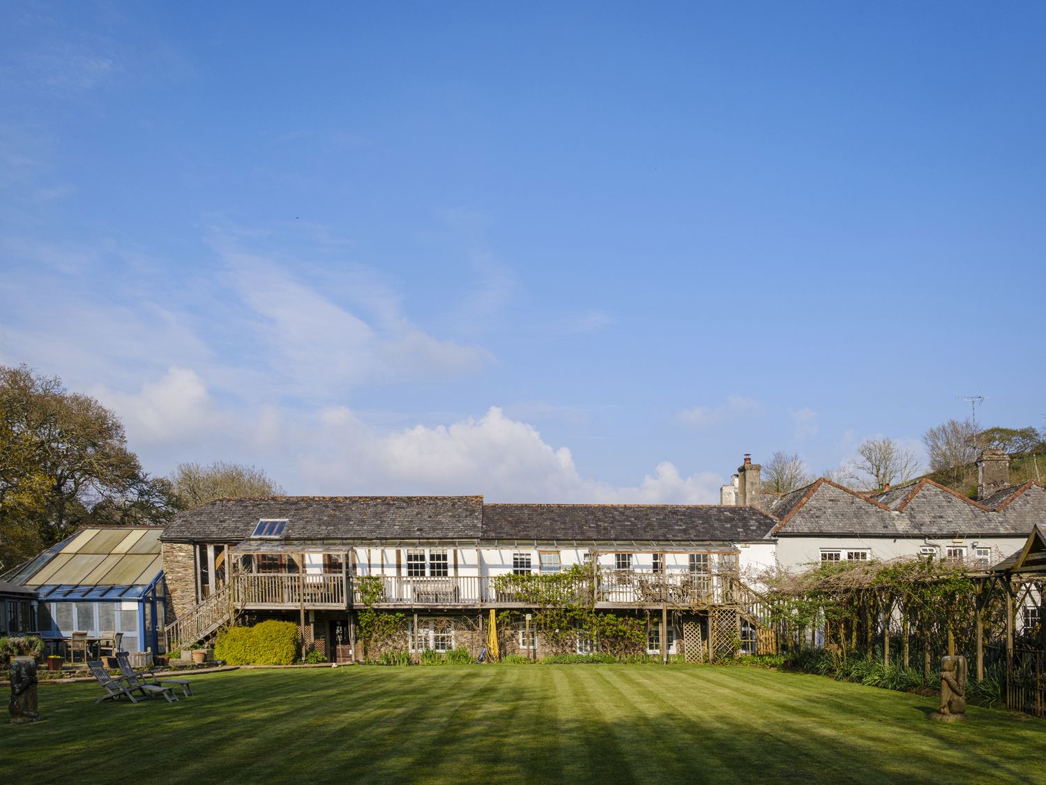 A garden with a house and balcony at Wisteria Suite in Dittisham