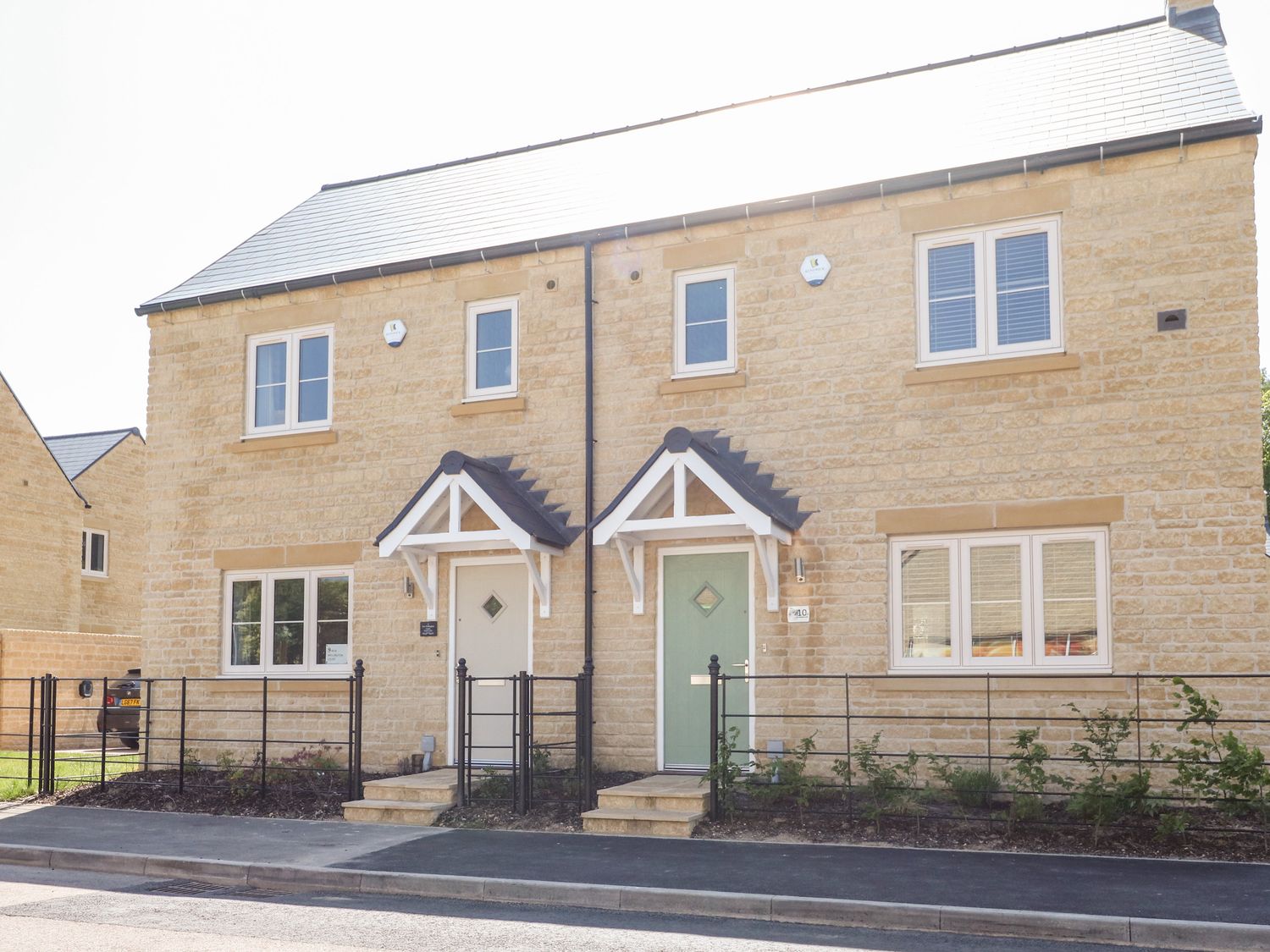 A semi detached house with two front doors and small porches at Beau's House in Upper Rissington near Bourton-On-The-Water