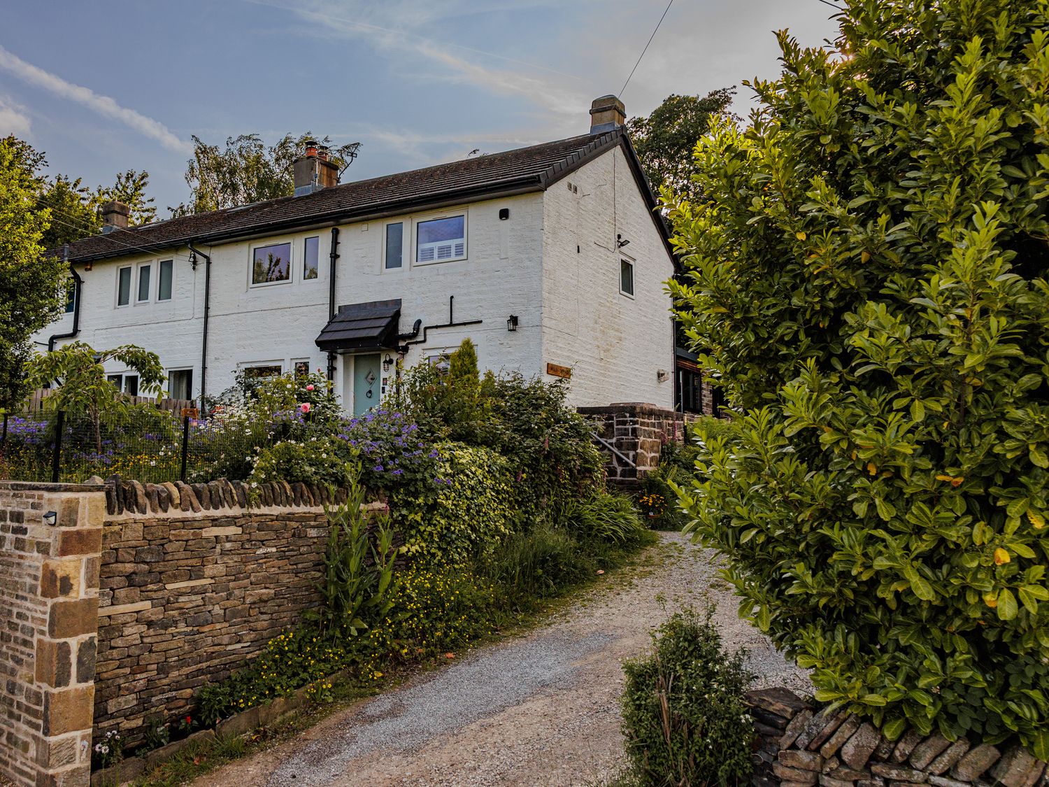 A house with a driveway and garden at Wells Cottage in Holmfirth