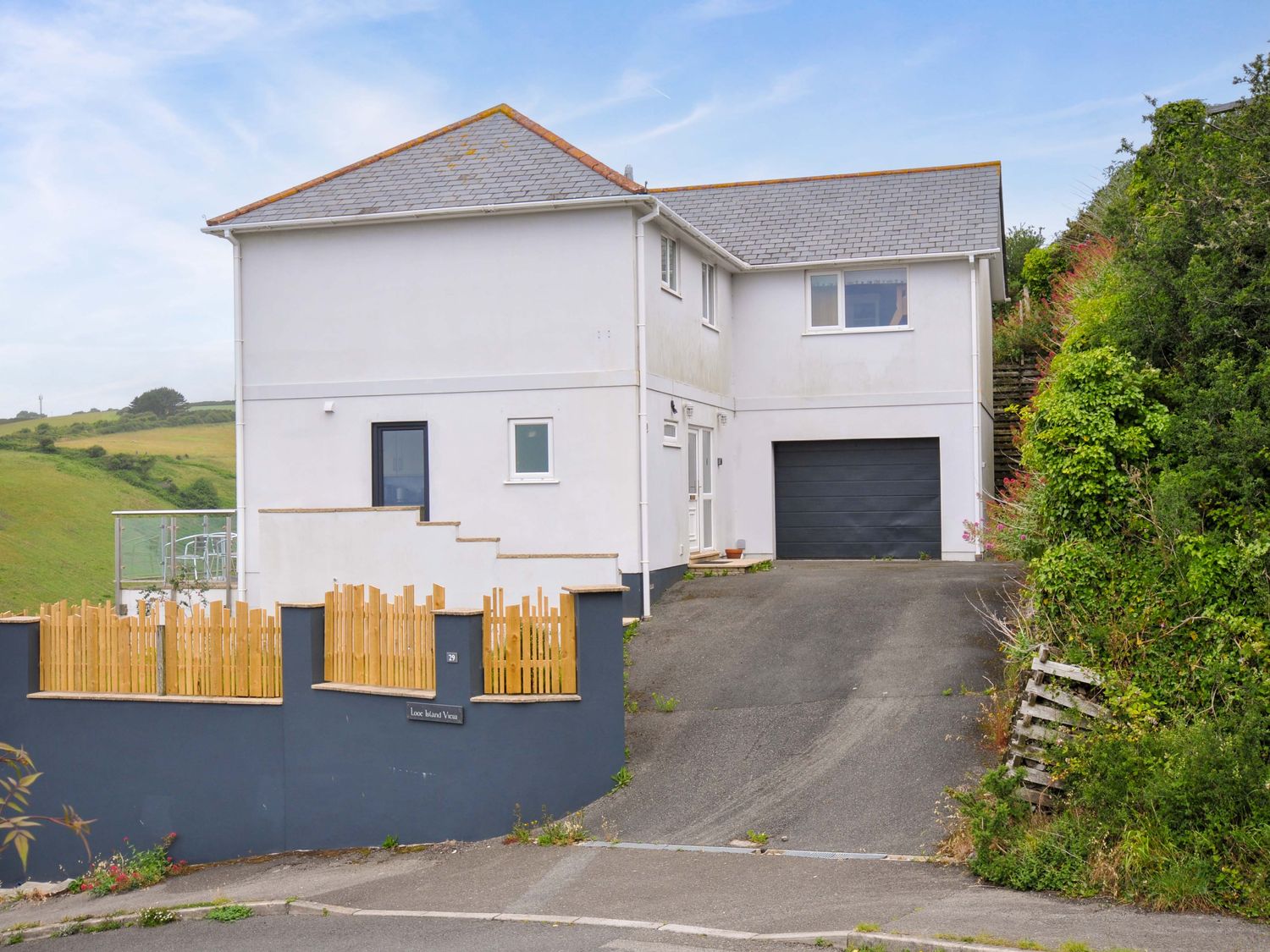 A house with a garage and driveway at Looe Island View in Downderry