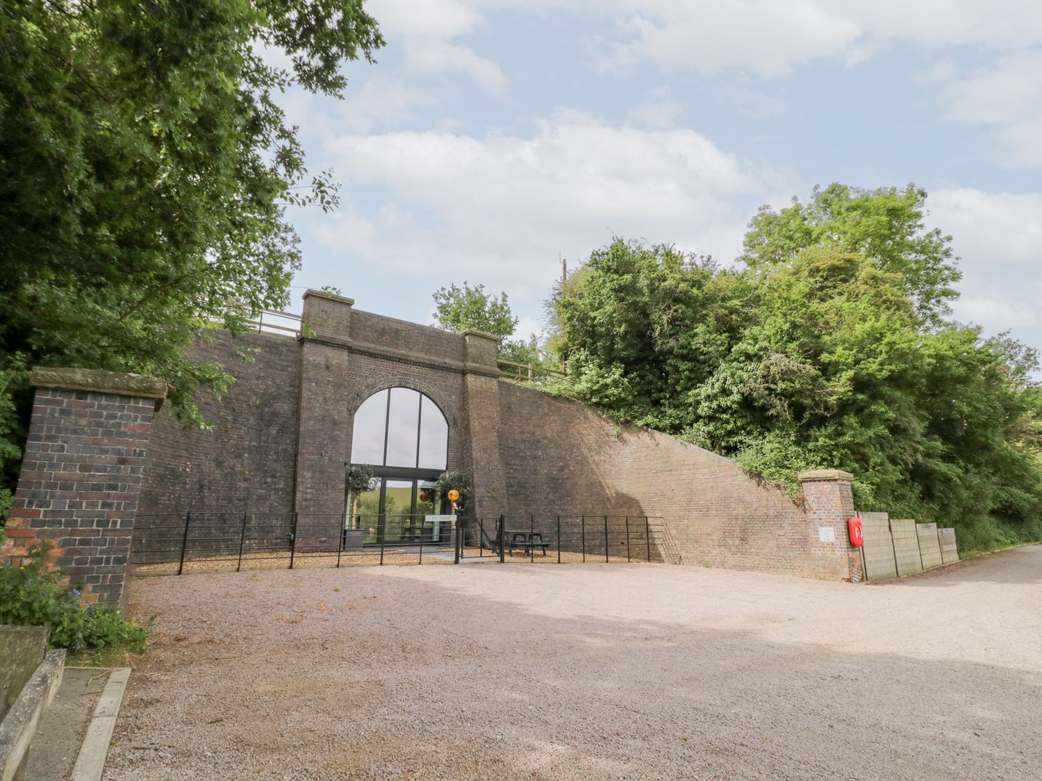 A building with a large window and pathway at The Tunnel at Bridge Lake Farm and Fishery Chacombe