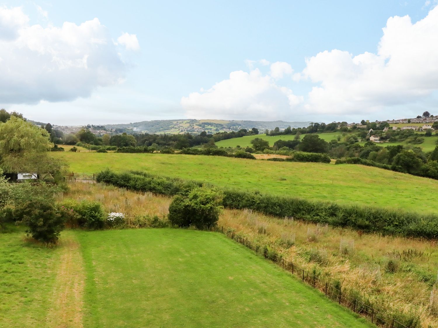 A rural landscape with green fields trees and distant hills at Hammonds Farmhouse in Stroud