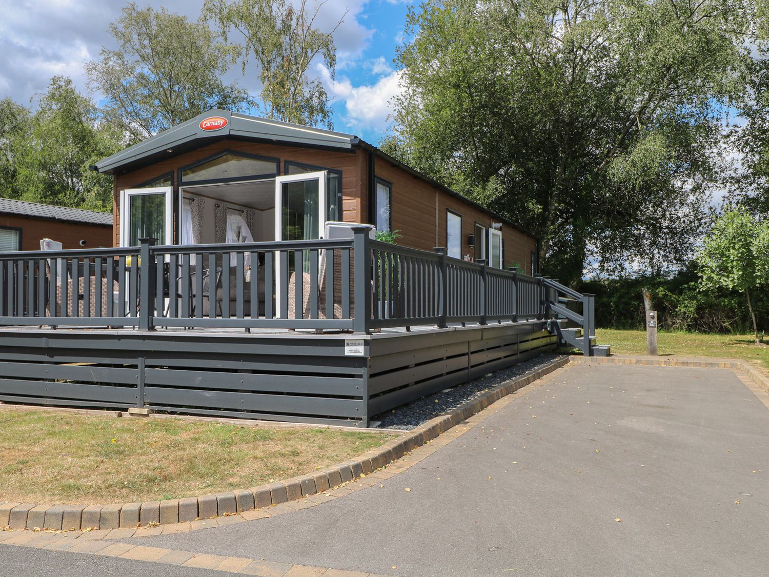 A cabin with a deck and steps at 18 Deer Glade in Landford