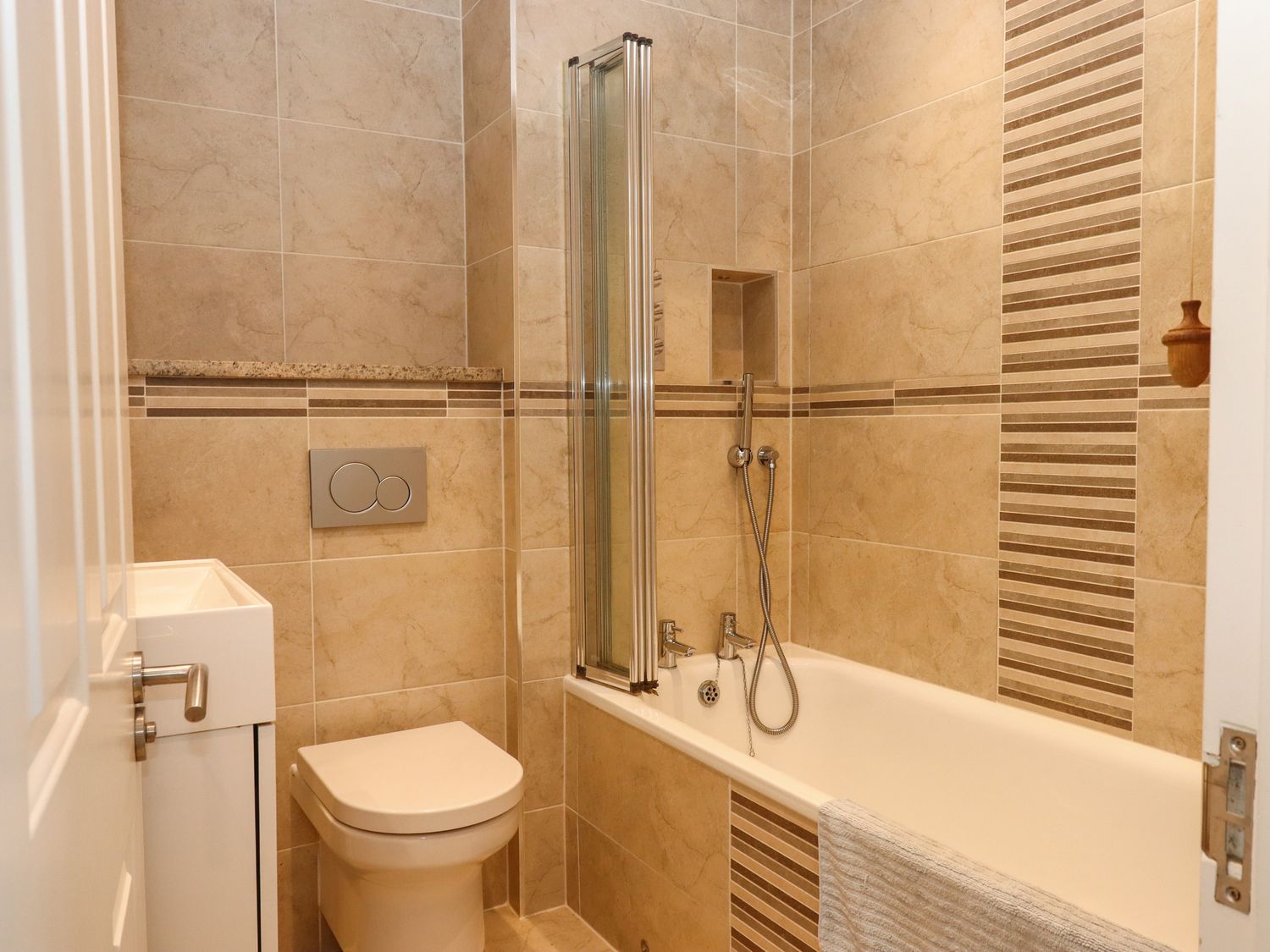A bathroom with a toilet bathtub and a small sink at 14 Burgh Island Causeway in Bigbury-On-Sea