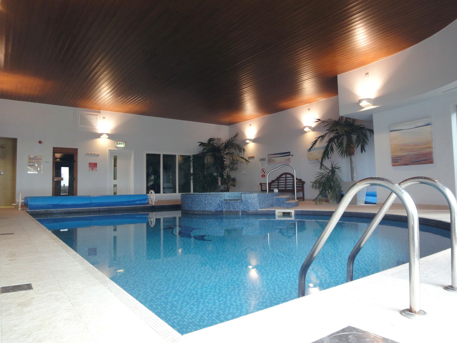 An indoor swimming pool with tiled floor and metal handrails at 14 Burgh Island Causeway in Bigbury-On-Sea