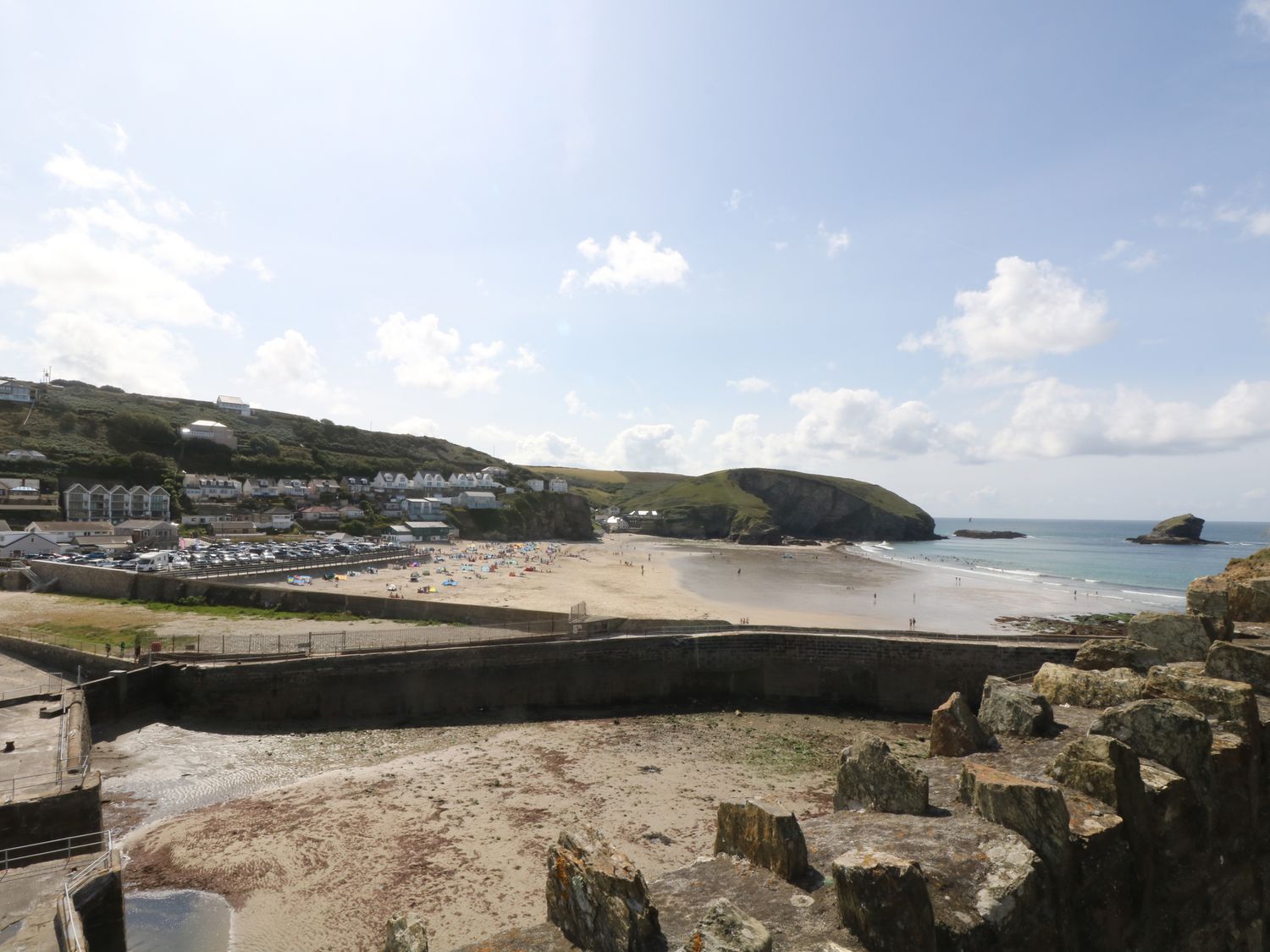 A coastal view with a sandy beach buildings and hills at Apple Tree Bungalow in Lanner