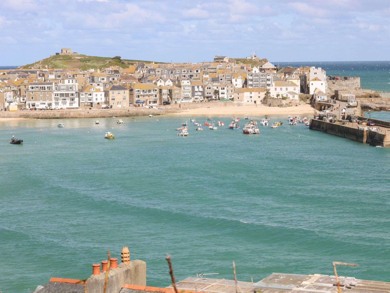 A coastal town with boats in the water and buildings along the shore at Bramble Barn in St Ives