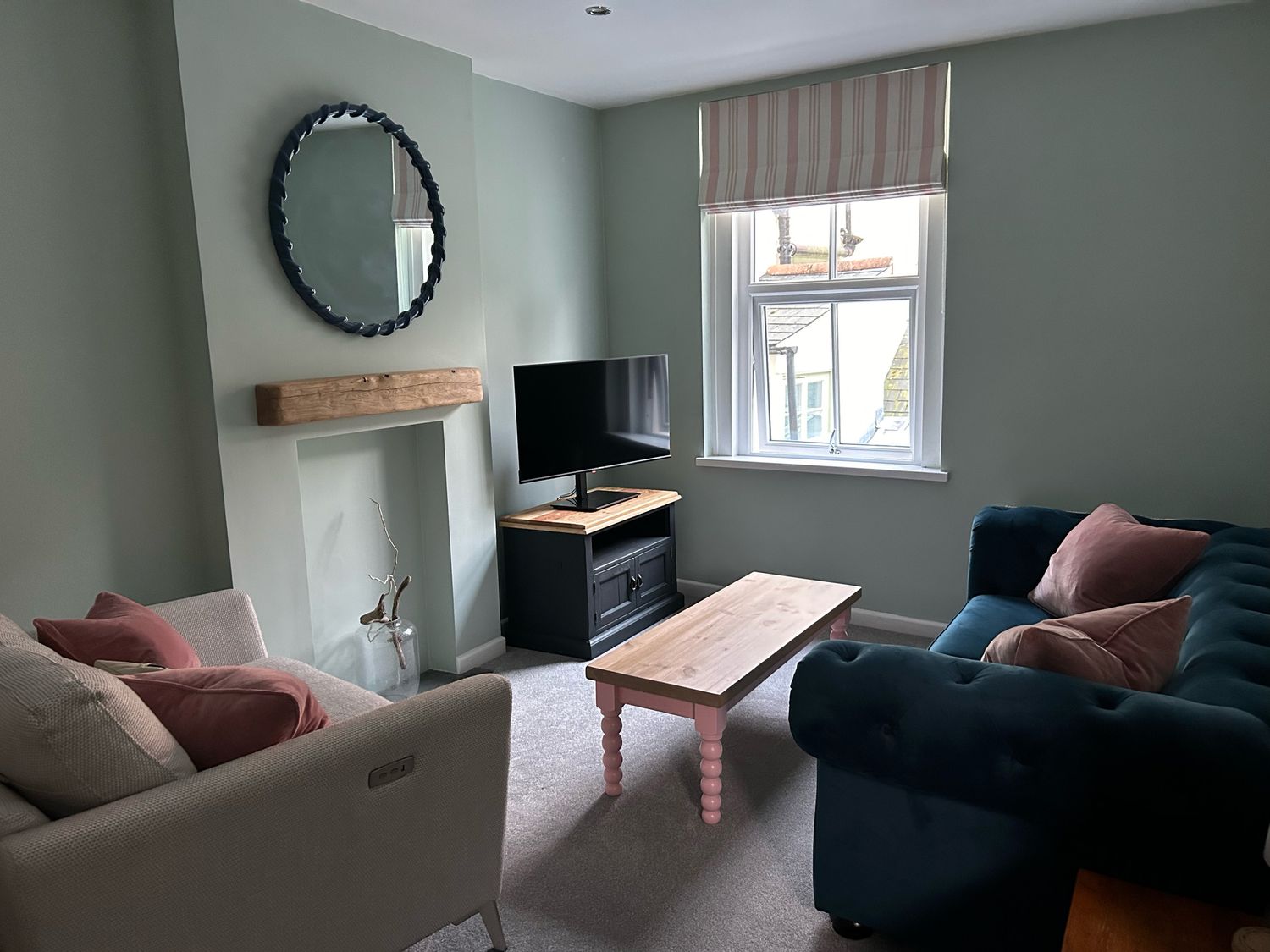 A living room with sofas a coffee table a television on a stand and a window at Secret Garden 34C Clarence Street Dartmouth