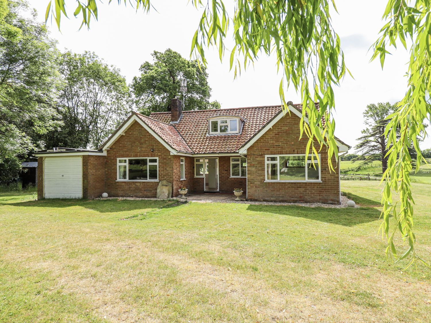 A house with a garage and lawn at Lake View Cottage in Well near Alford