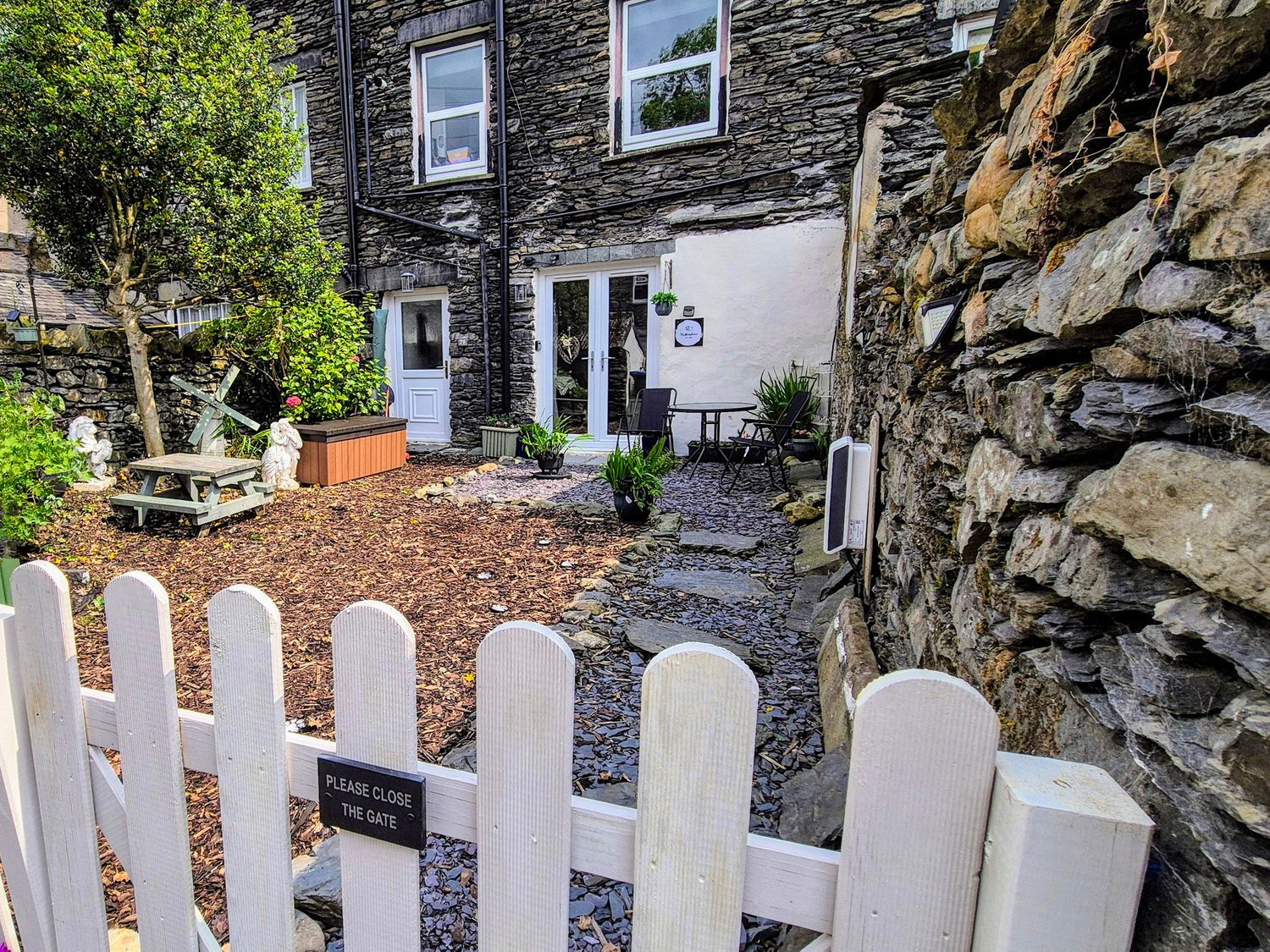 An outdoor area with a gate and seating at The Wonky Burrow in Bowness-On-Windermere