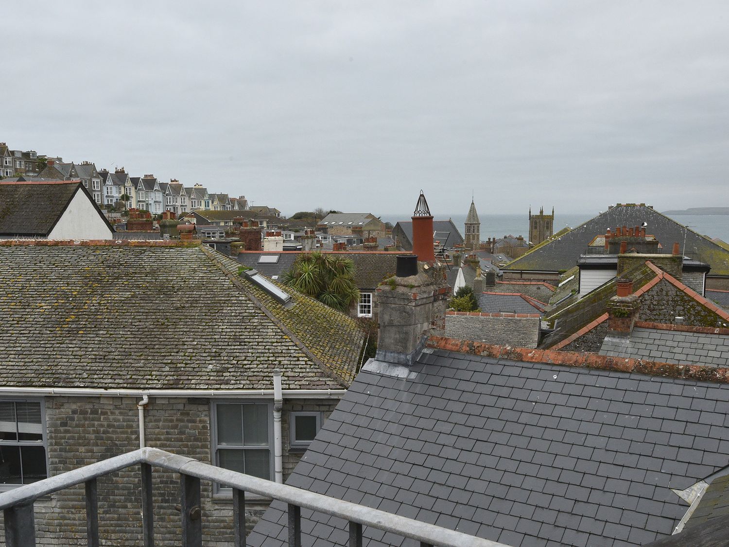 A view of rooftops and church towers with the sea in the background at 5 St Ives in St Ives