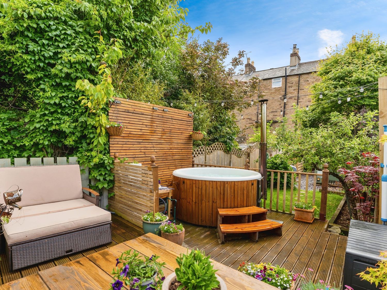 A garden with a hot tub and seating area at Rivendell in Ffynnongroyw
