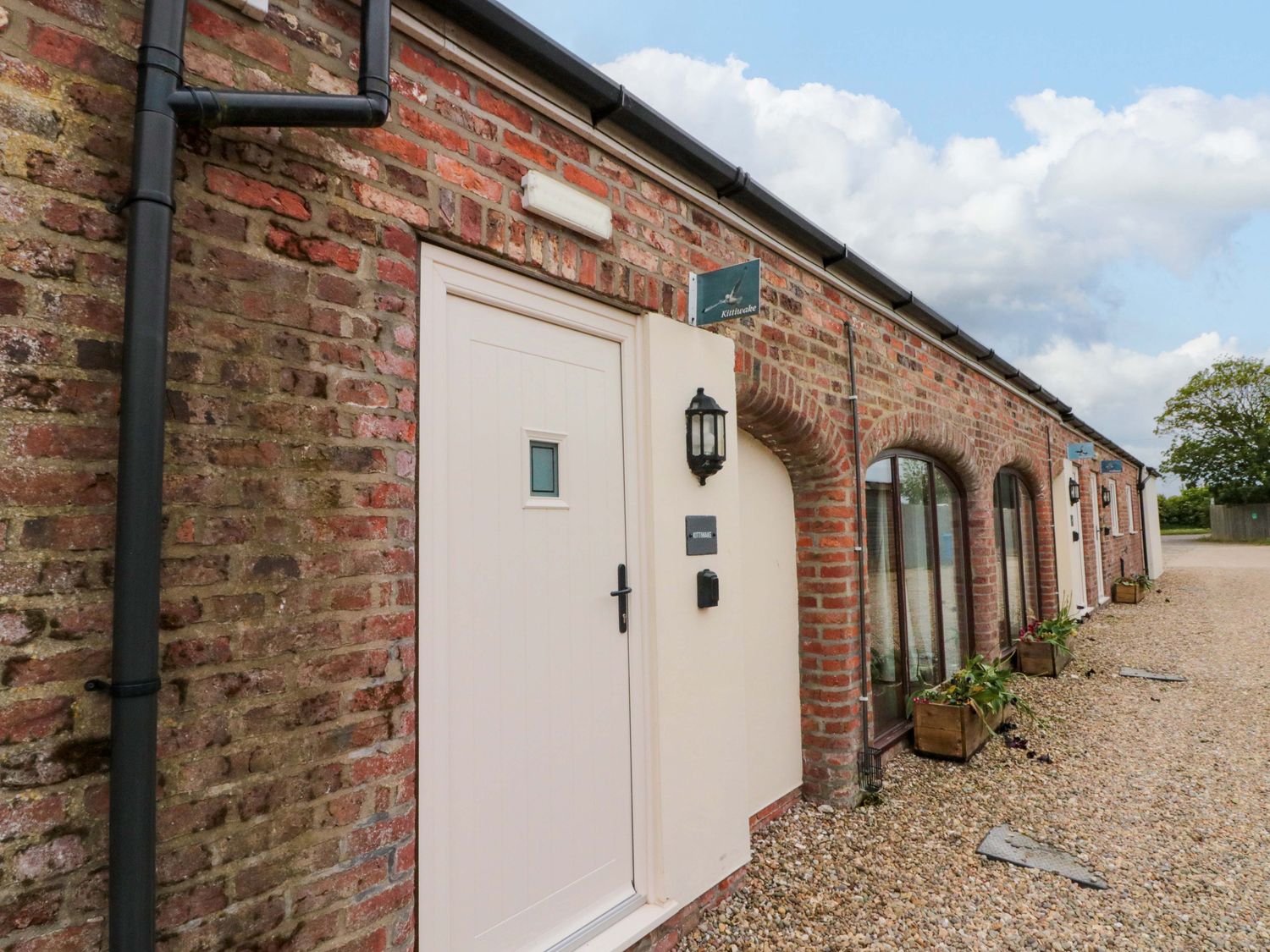 An exterior view of a building with a door and windows at Kittiwake in Flamborough