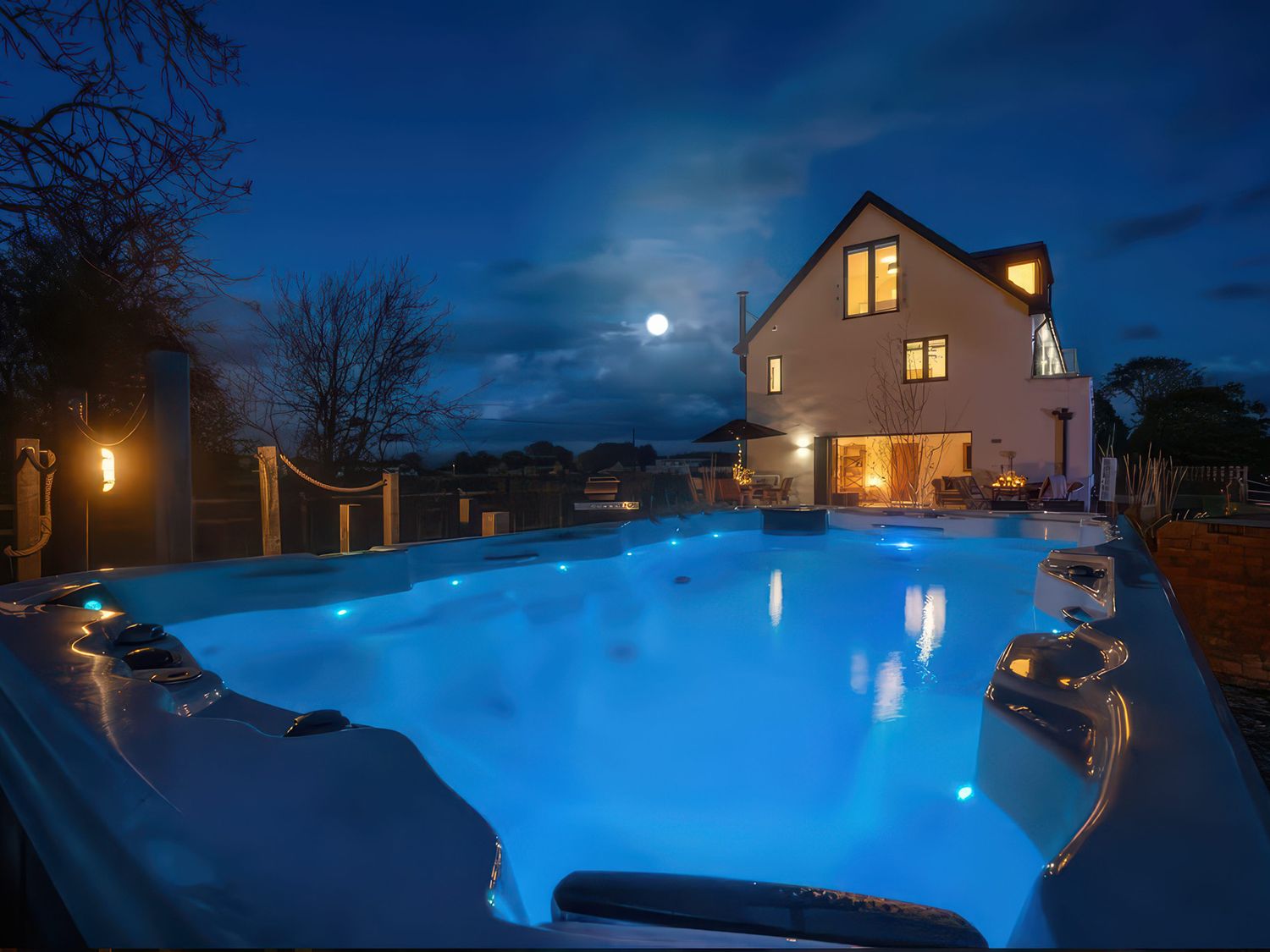 A swimming pool with a house in the background at Station House Highbridge
