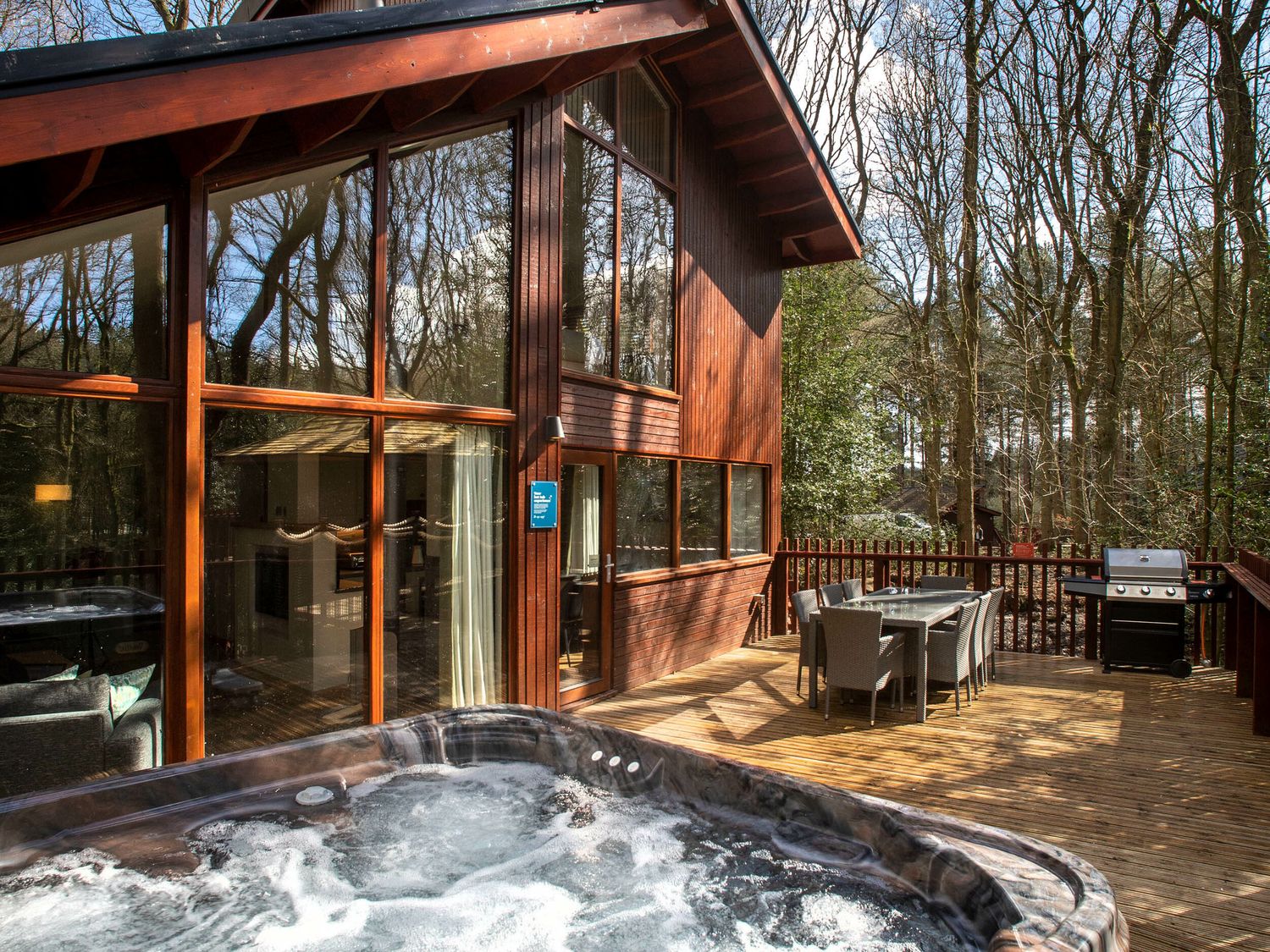 An outdoor area with a hot tub and dining set at Delamere Forest Golden Oak Delamere Forest