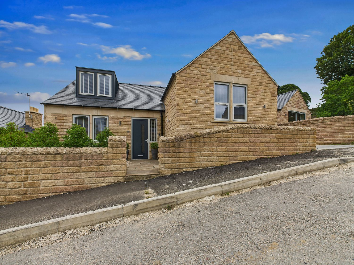 A house with a stone exterior and front door at Oakwood Lodge Tansley