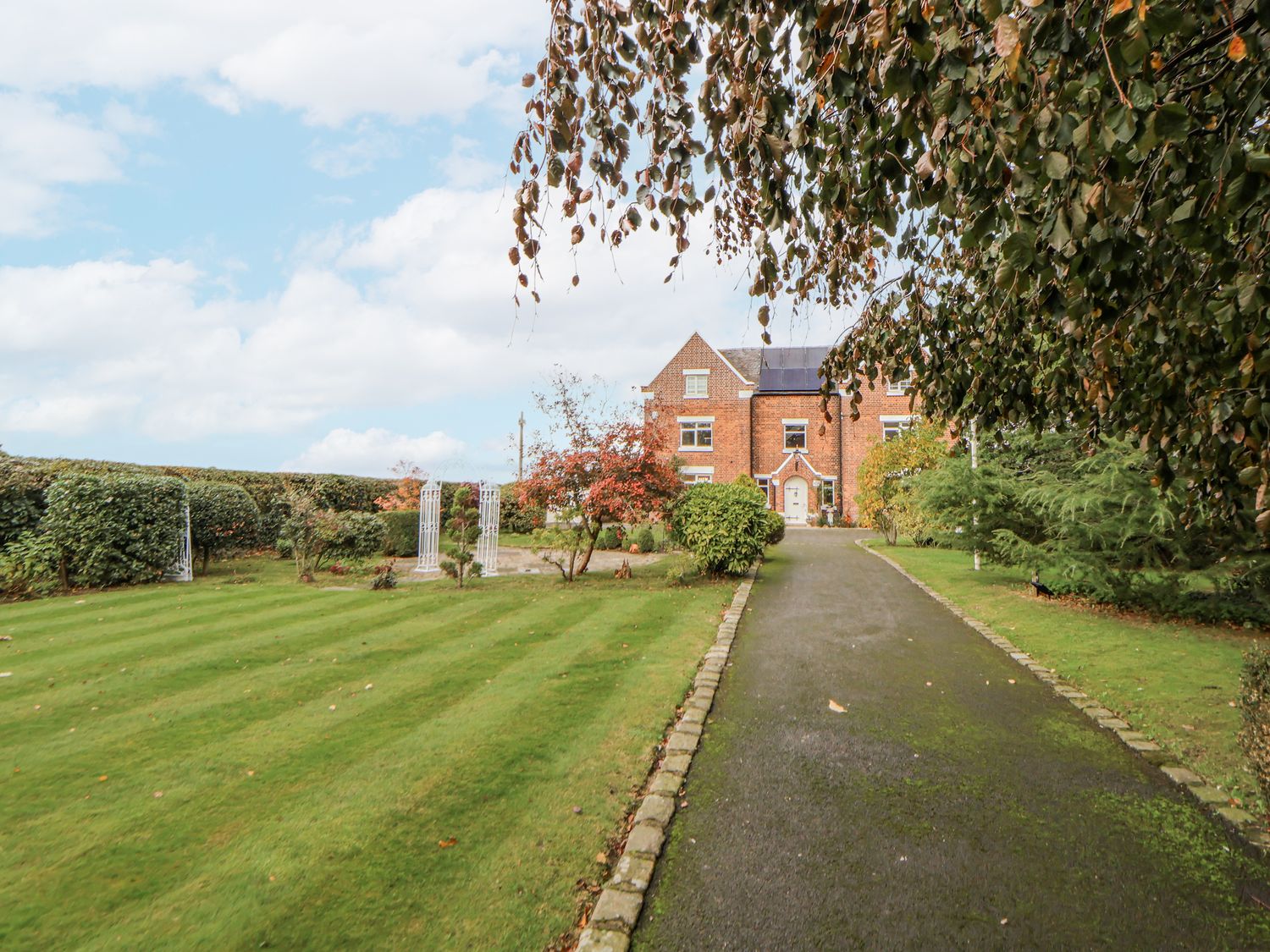 An outdoor area with a house and garden at The House at School Farm in Hassall near Haslington