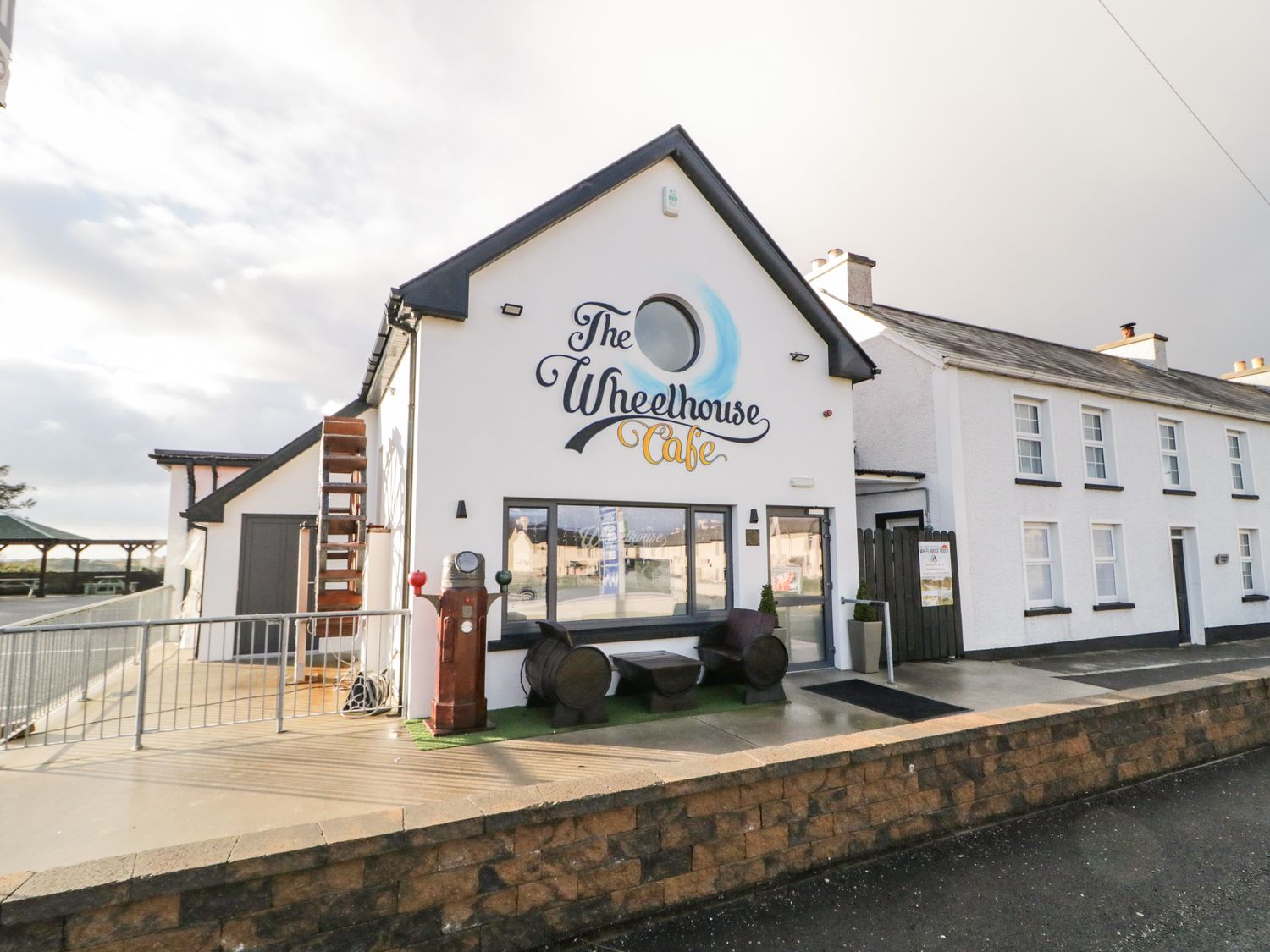The exterior of The Wheelhouse Cafe with seating and vintage gas pumps at The Wheelhouse Pod No 8 Burtonport County Donegal