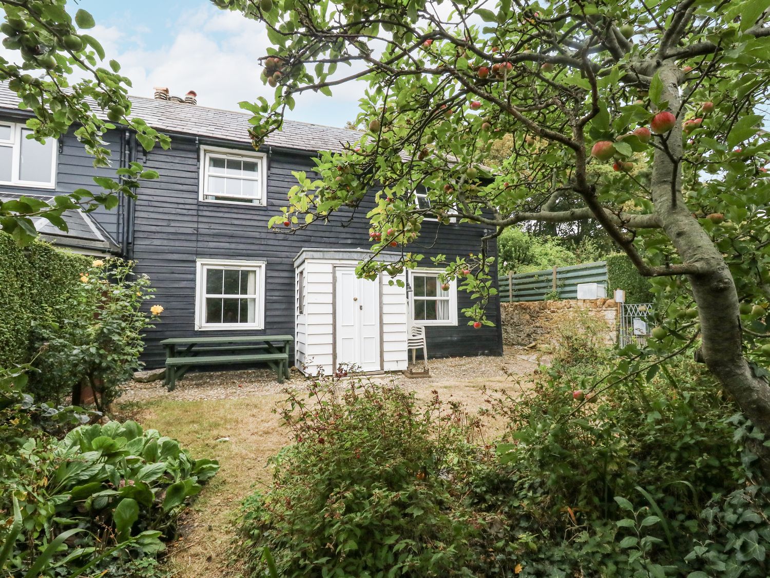 A house with a garden and bench at Chenies, Osmington Mills, near Preston