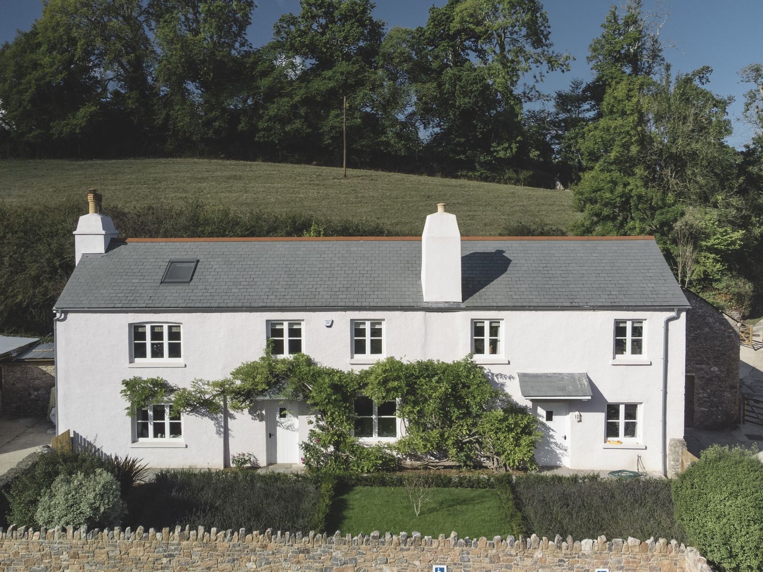 An exterior view of a house with a garden at Lower Well Farm House in Totnes