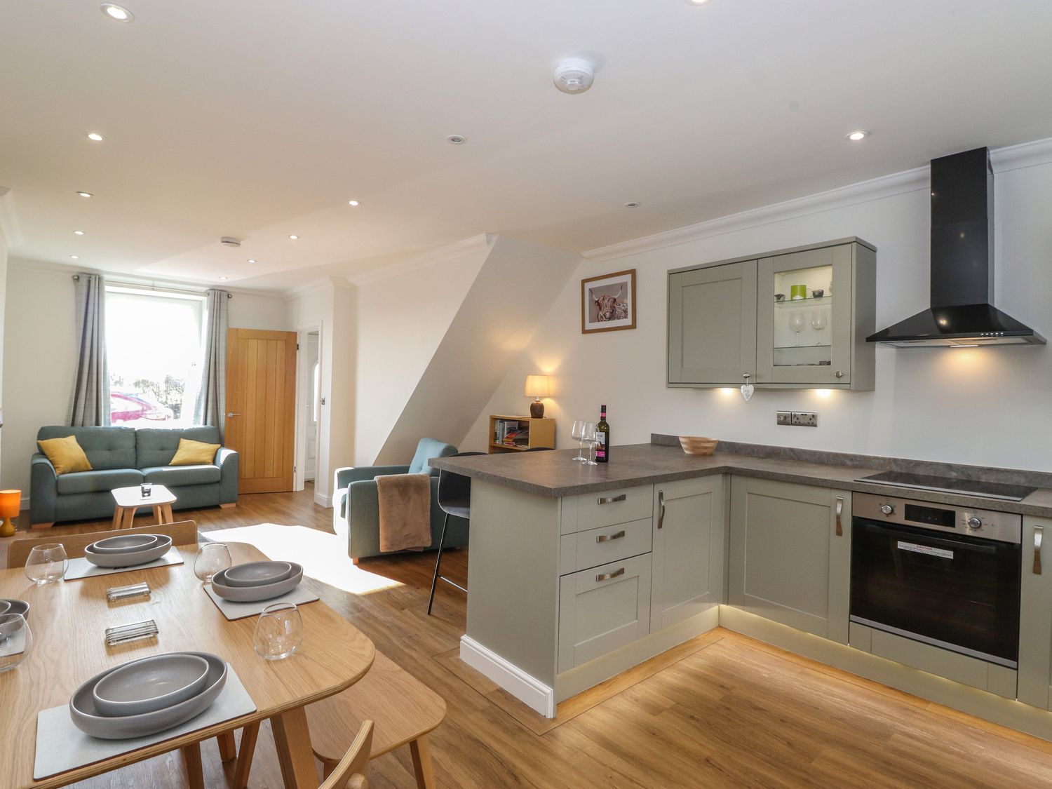 An open plan kitchen and living area with dining table and chairs at 2 South Street in Fletchertown near Aspatria