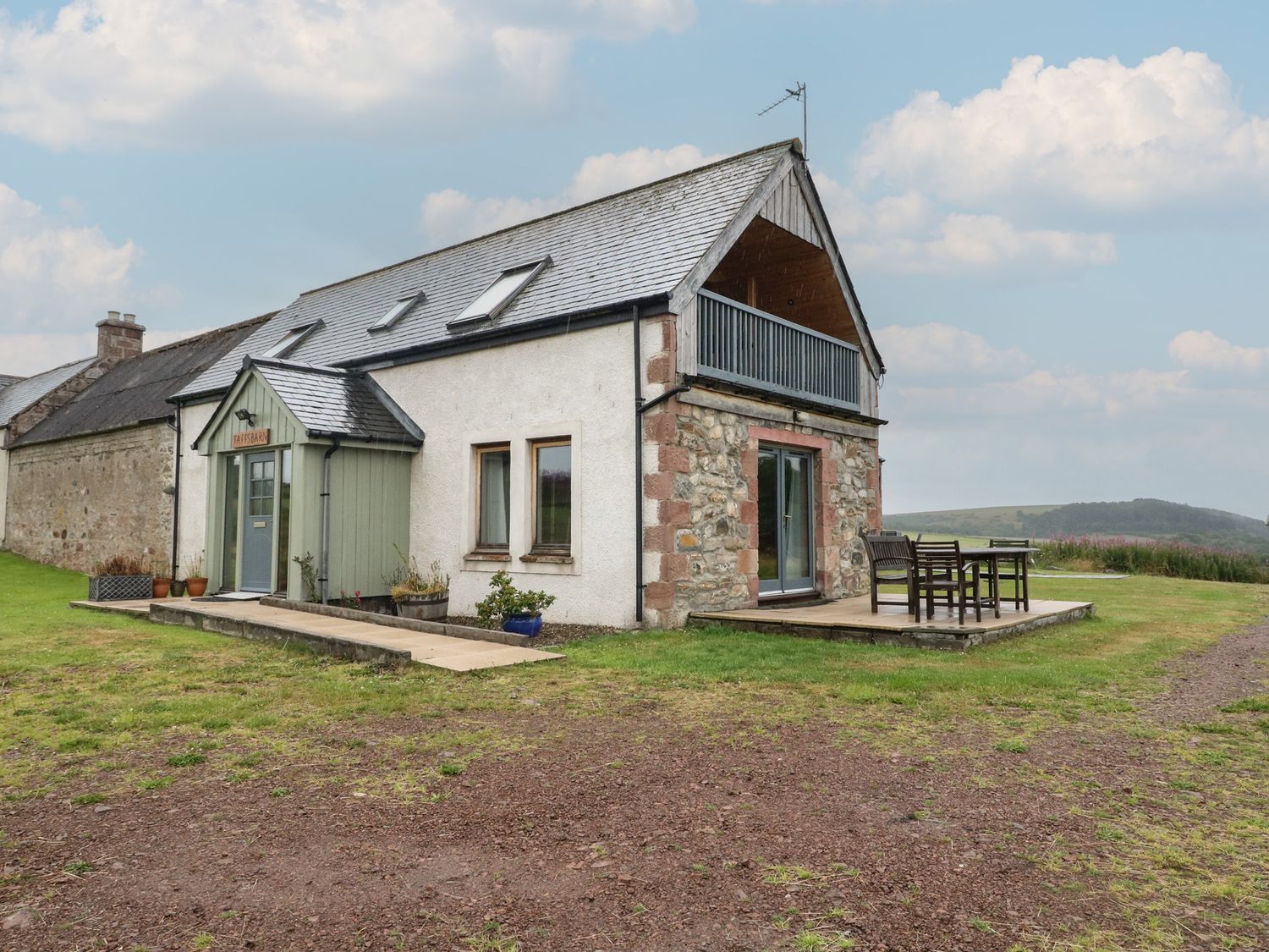 A house with a deck and furniture at Taffs Barn Fortrose near Rosemarkie