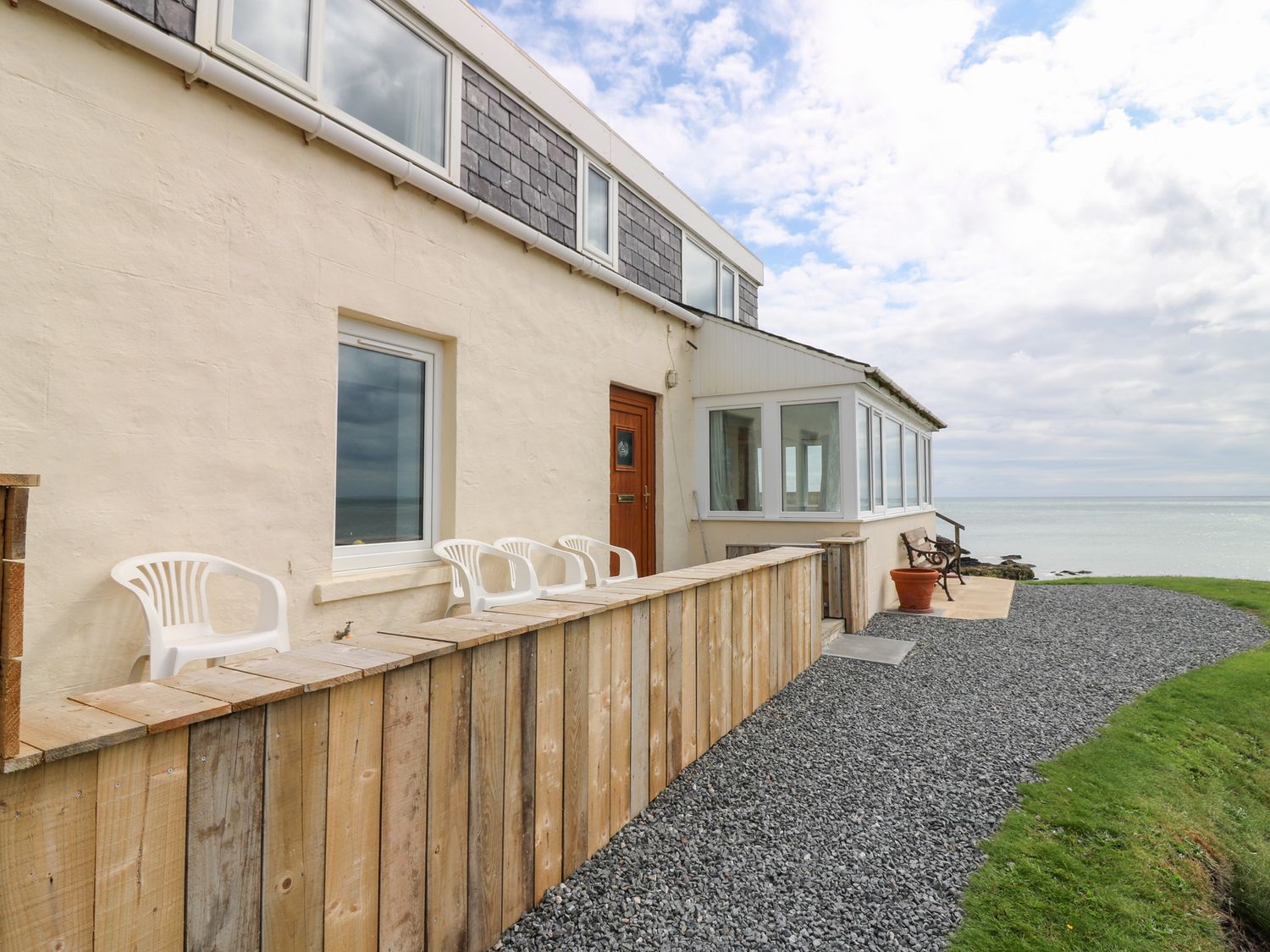 An exterior view of a building with chairs and gravel at The Breakers in Newburgh, Aberdeenshire