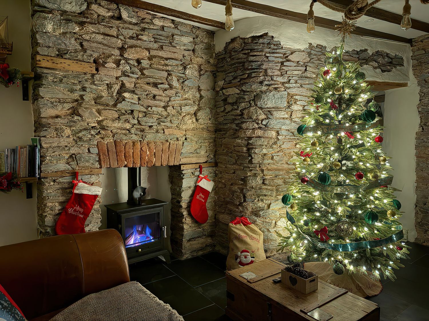 A living room with a Christmas tree and fireplace at The Nook in Brixham