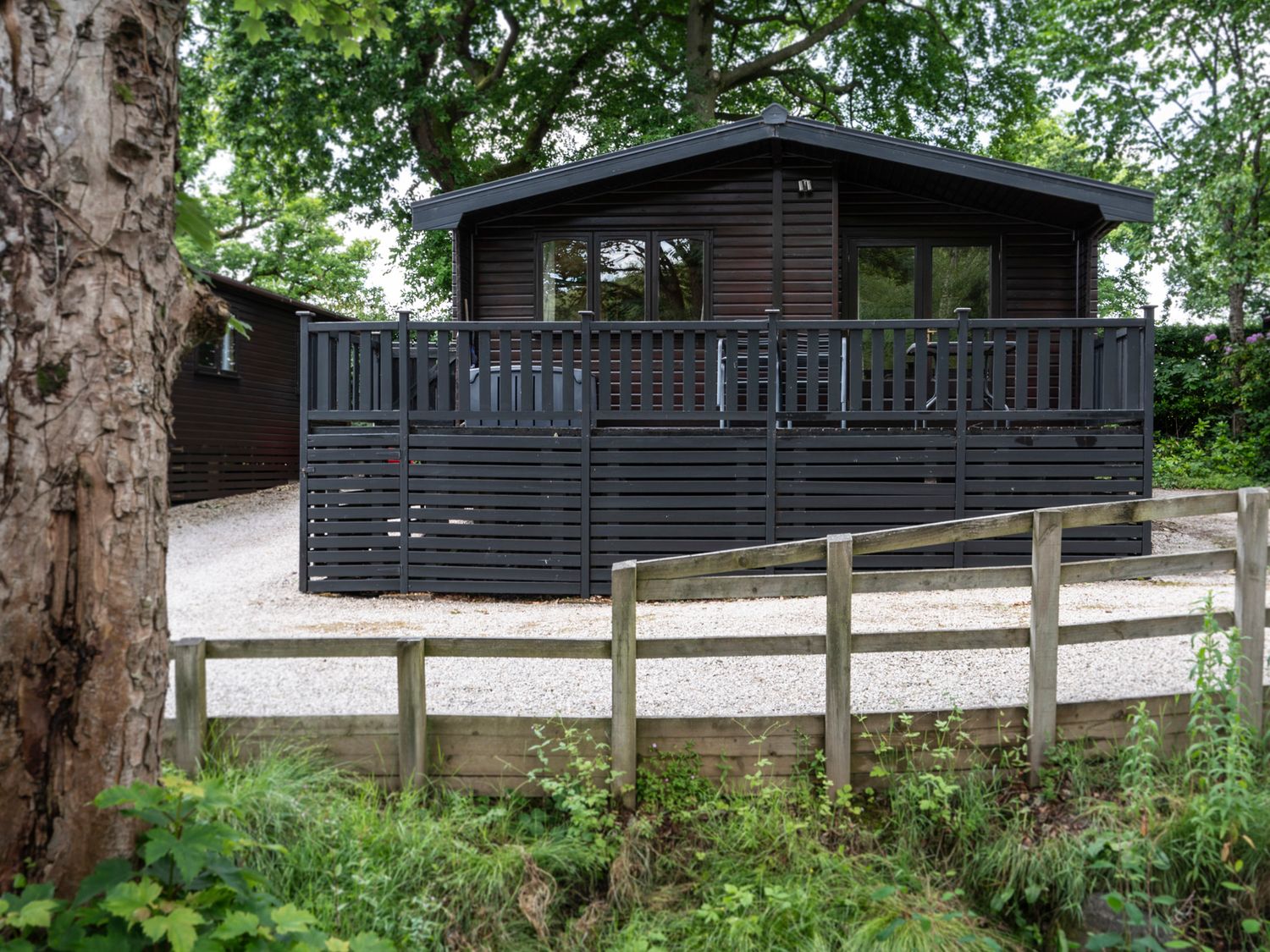 A cabin with a deck and fence at Watendlath in Keswick