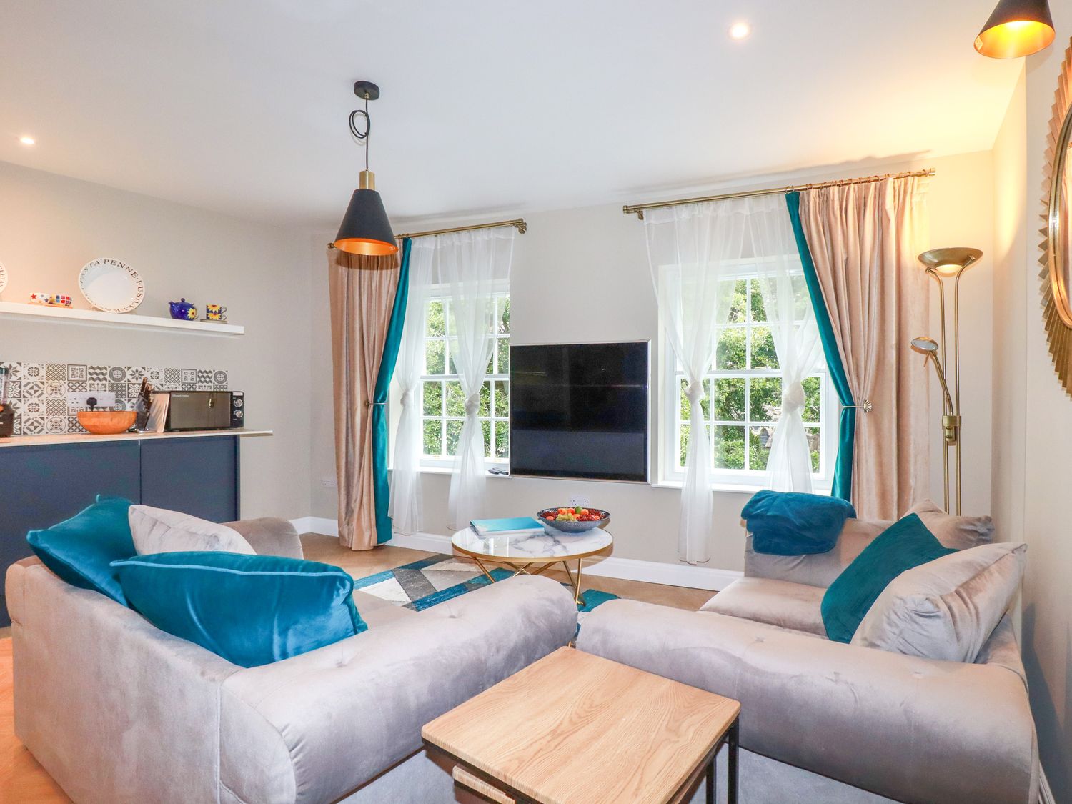 A living room with two sofas and a wall-mounted tv at Kerensa in St Austell