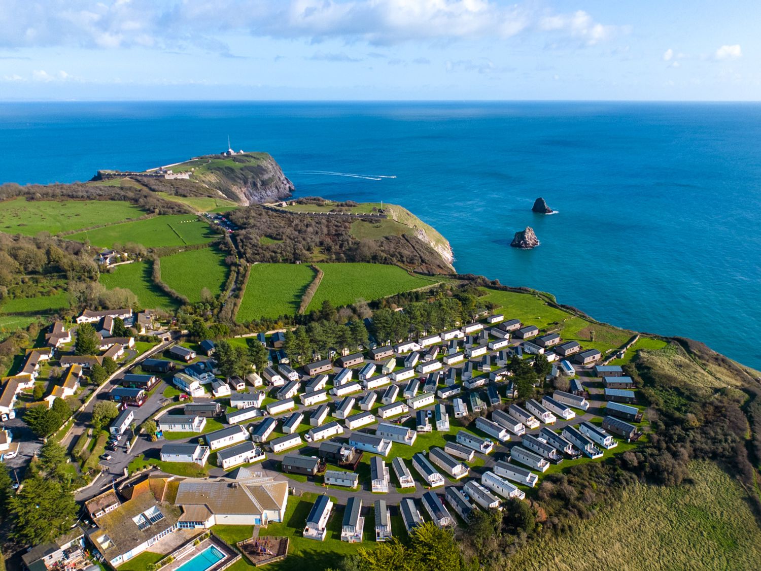 An outdoor view of a holiday park with mobile homes and coastline at Chalet 31 at Landscove Holiday Park Brixham